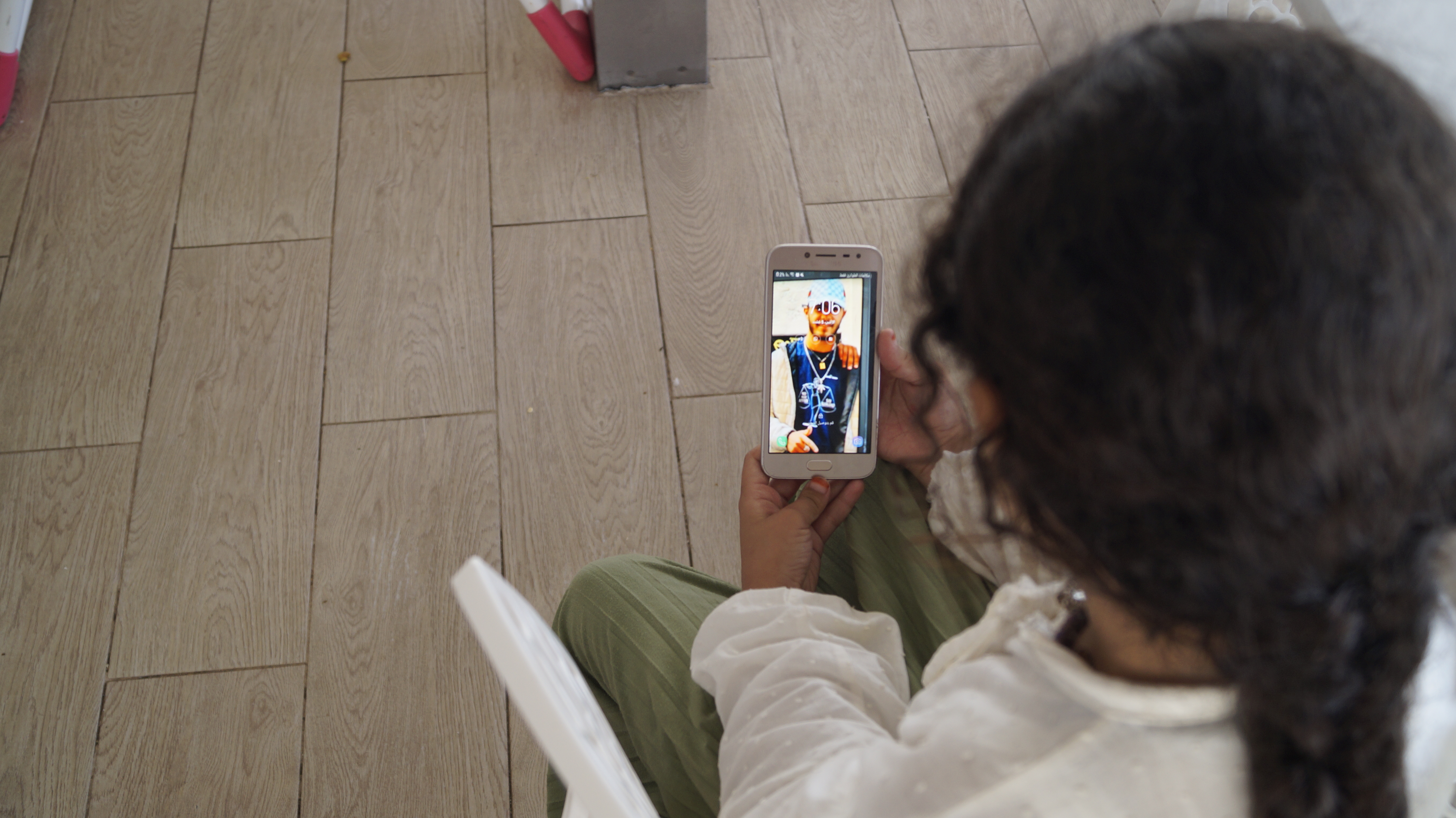 Ilyas’s youngest sister, Chaymaa, 8, looks at his picture displayed on her mother’s phone