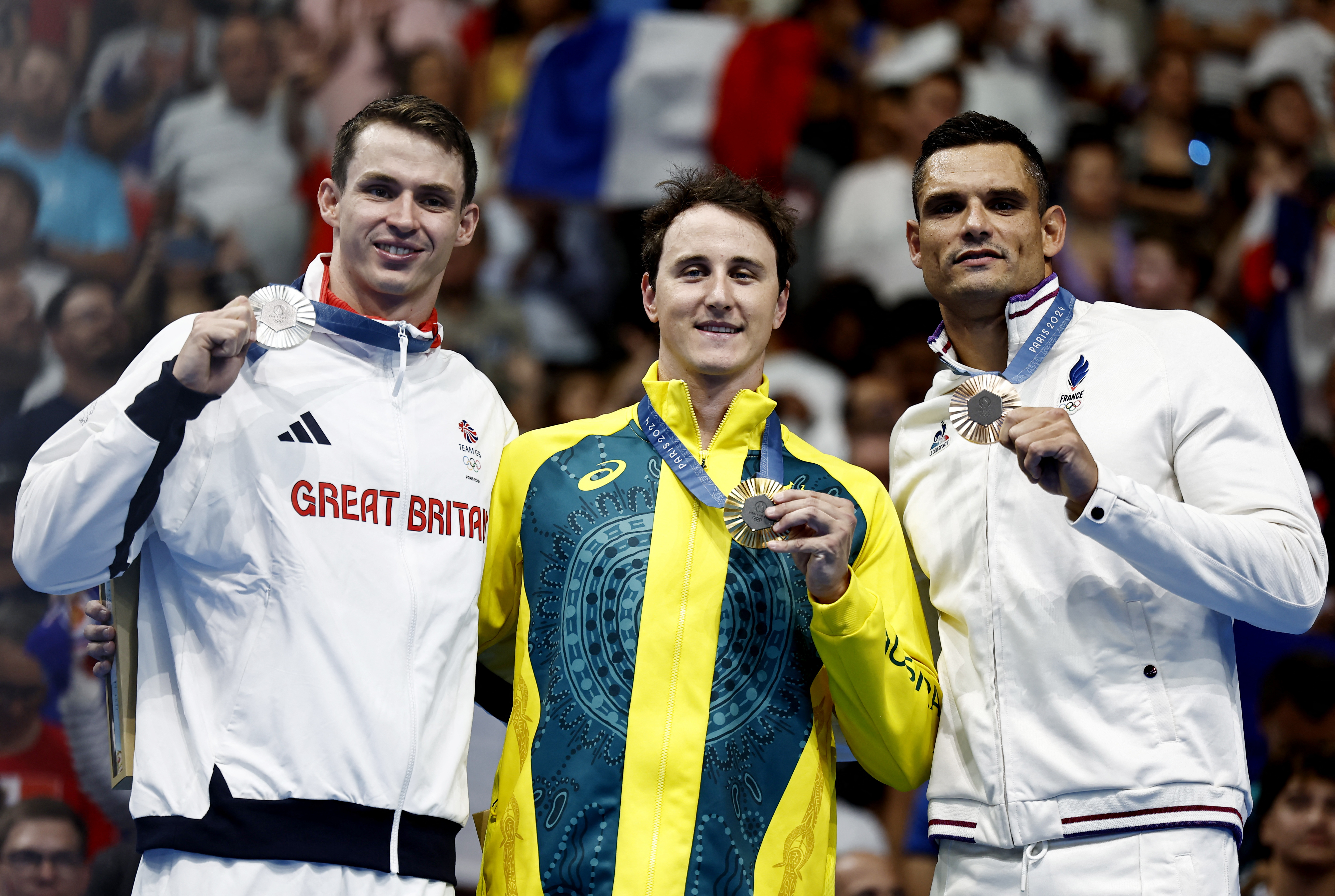 Paris 2024 Olympics - Swimming - Men's 50m Freestyle Victory Ceremony - Paris La Defense Arena, Nanterre, France - August 02, 2024. Gold medallist Cameron McEvoy of Australia celebrates on the podium with silver medallist Benjamin Proud of Britain and bronze medallistFlorent Manaudou of France. REUTERS/Clodagh Kilcoyne