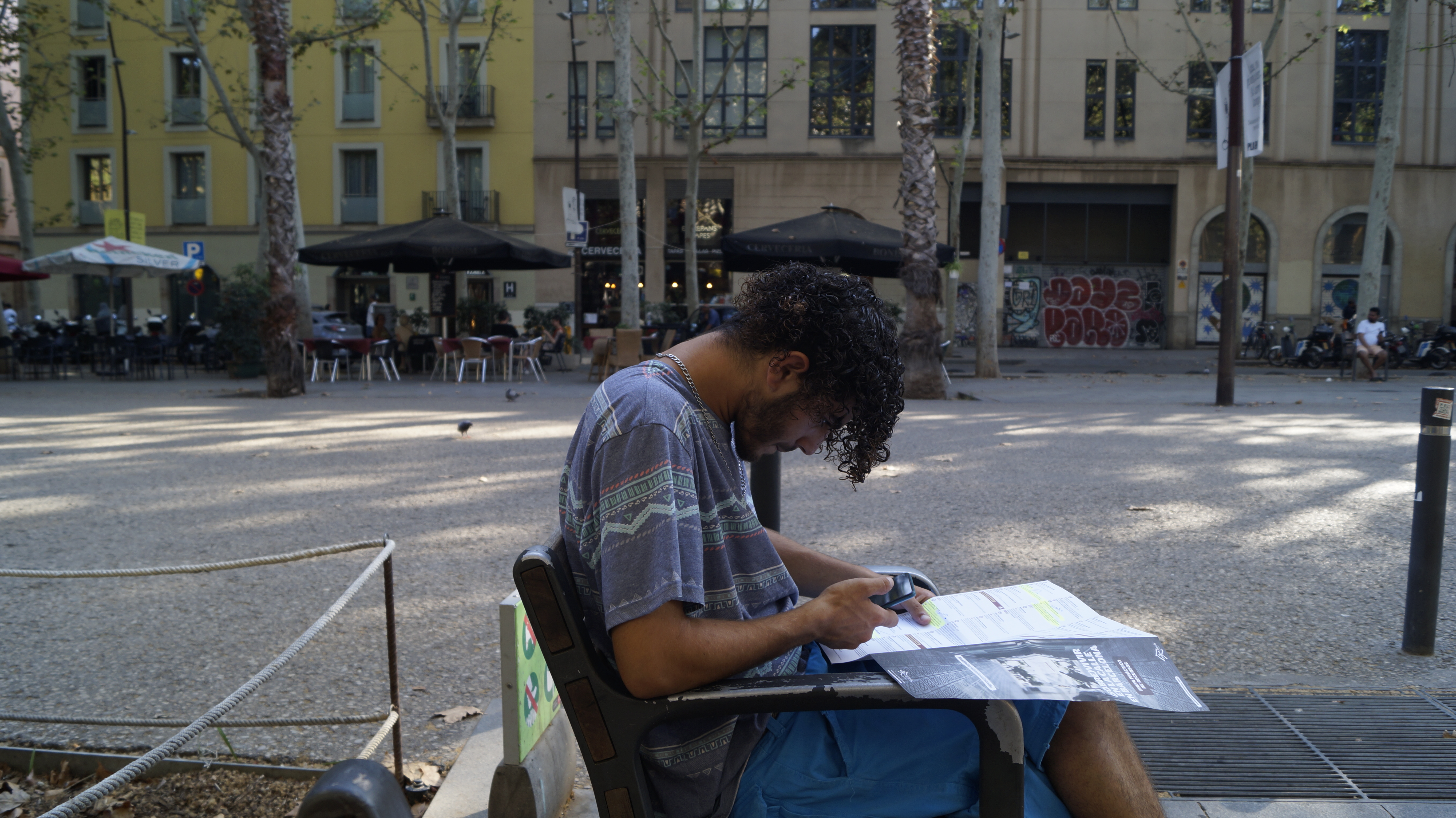 Ilyas sits on a bench as he looks at the map social services has given him, indicating where he can take a shower and eat during the nights he sleeps on the street