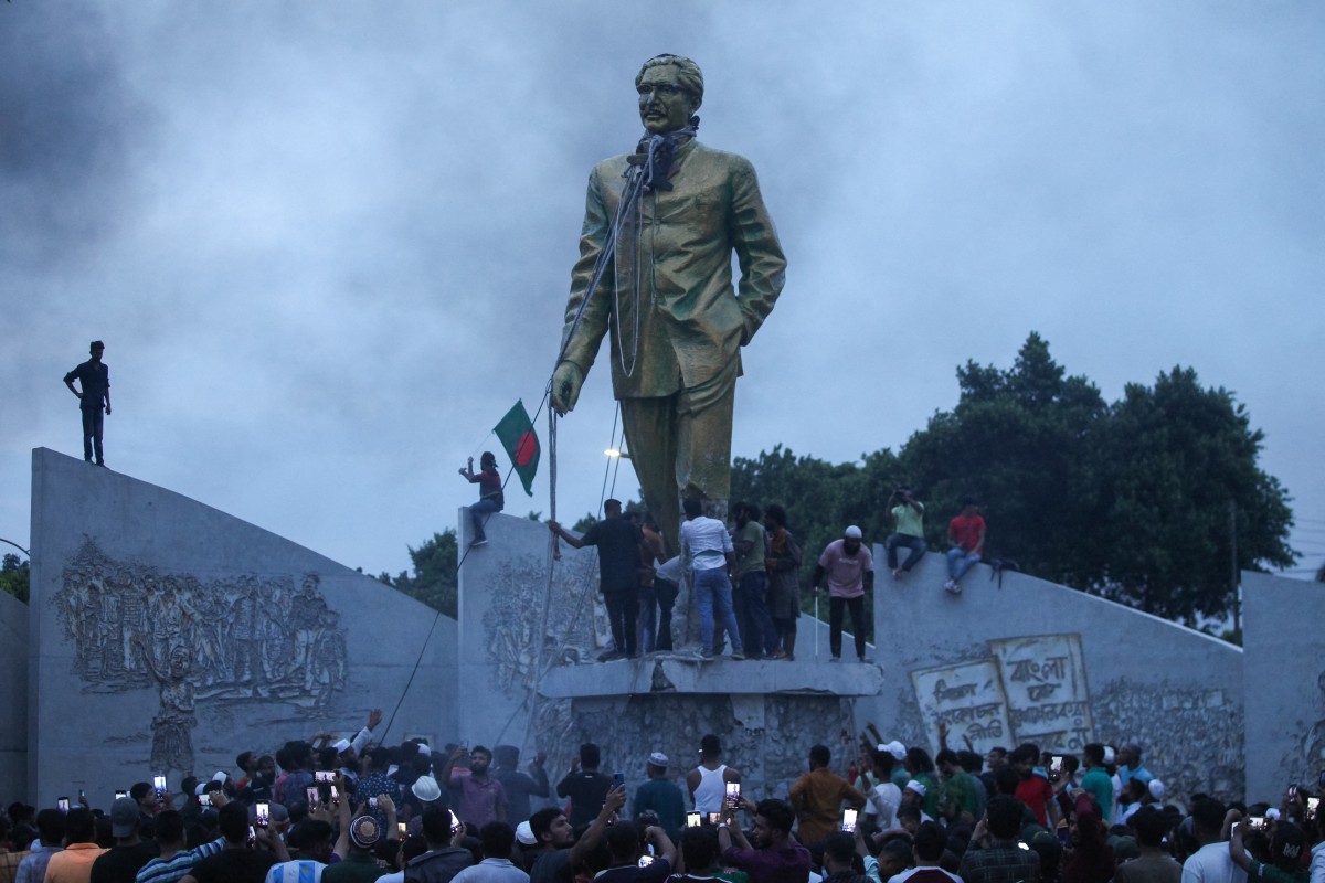 Anti-government protestors attempt to vandalise a statue of Hasina’s father Sheikh Mujibur Rahman in Dhaka on August 5, 2024