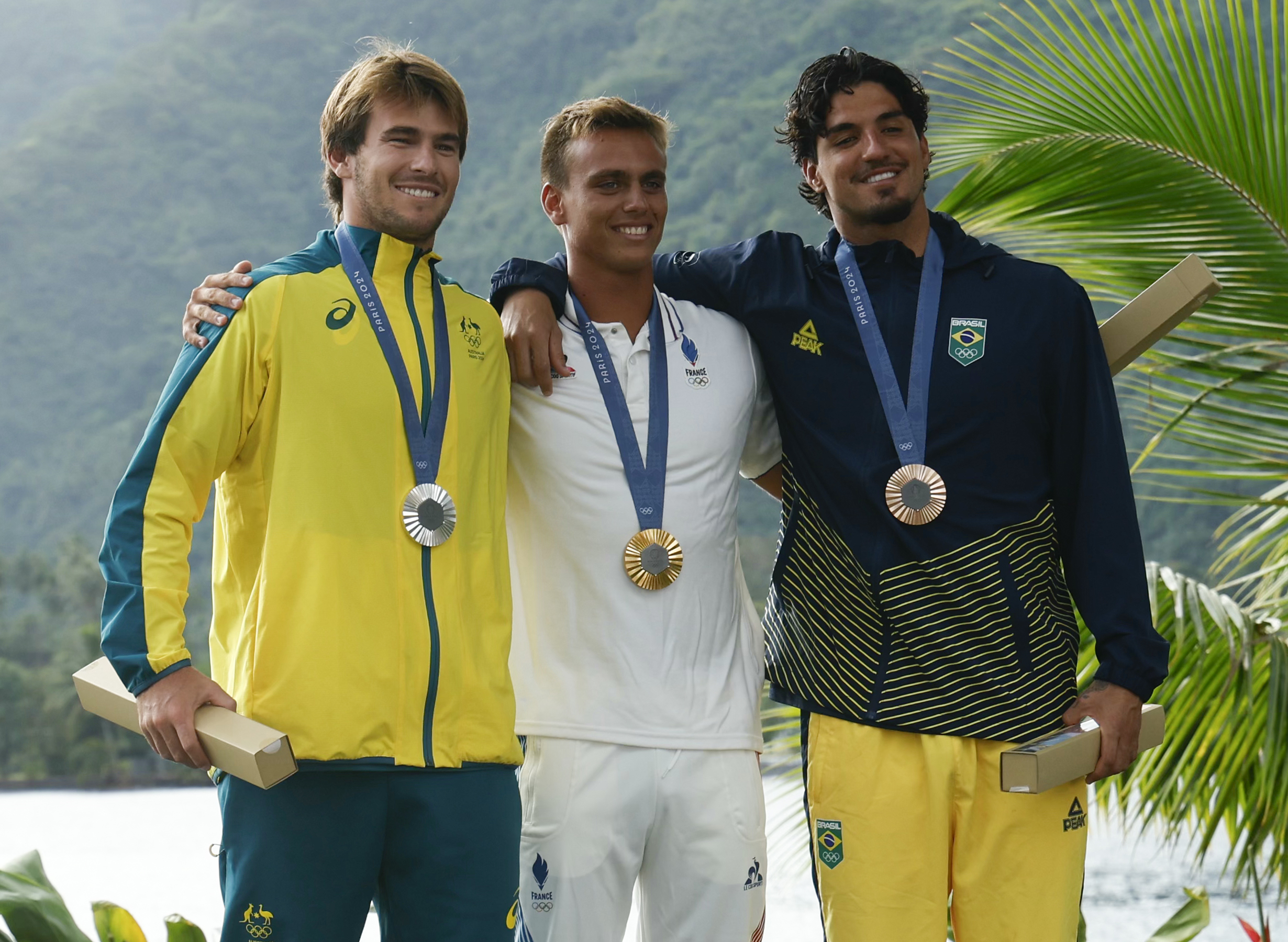 Men’s surfing silver medallist Jack Robinson of Australia, gold medallist Kauli Vaast of France and bronze medallist Gabriel Medina of Brazil attend the podium ceremony at the Paris 2024 Olympic Games on the French Polynesian Island of Tahiti