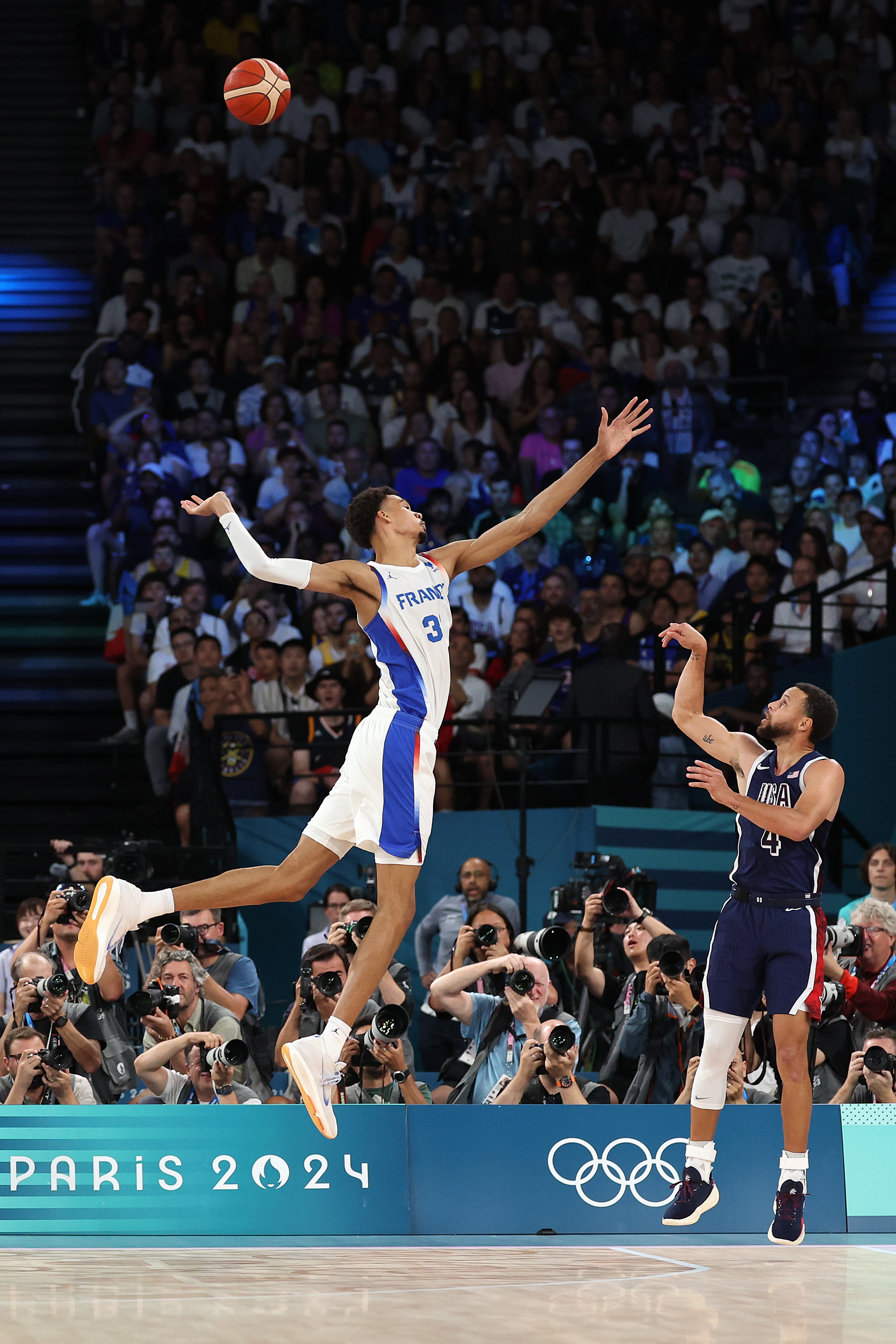 The USA’s Stephen Curry #4 shoots over Victor Wembanyama #32 of France during the gold medal game
