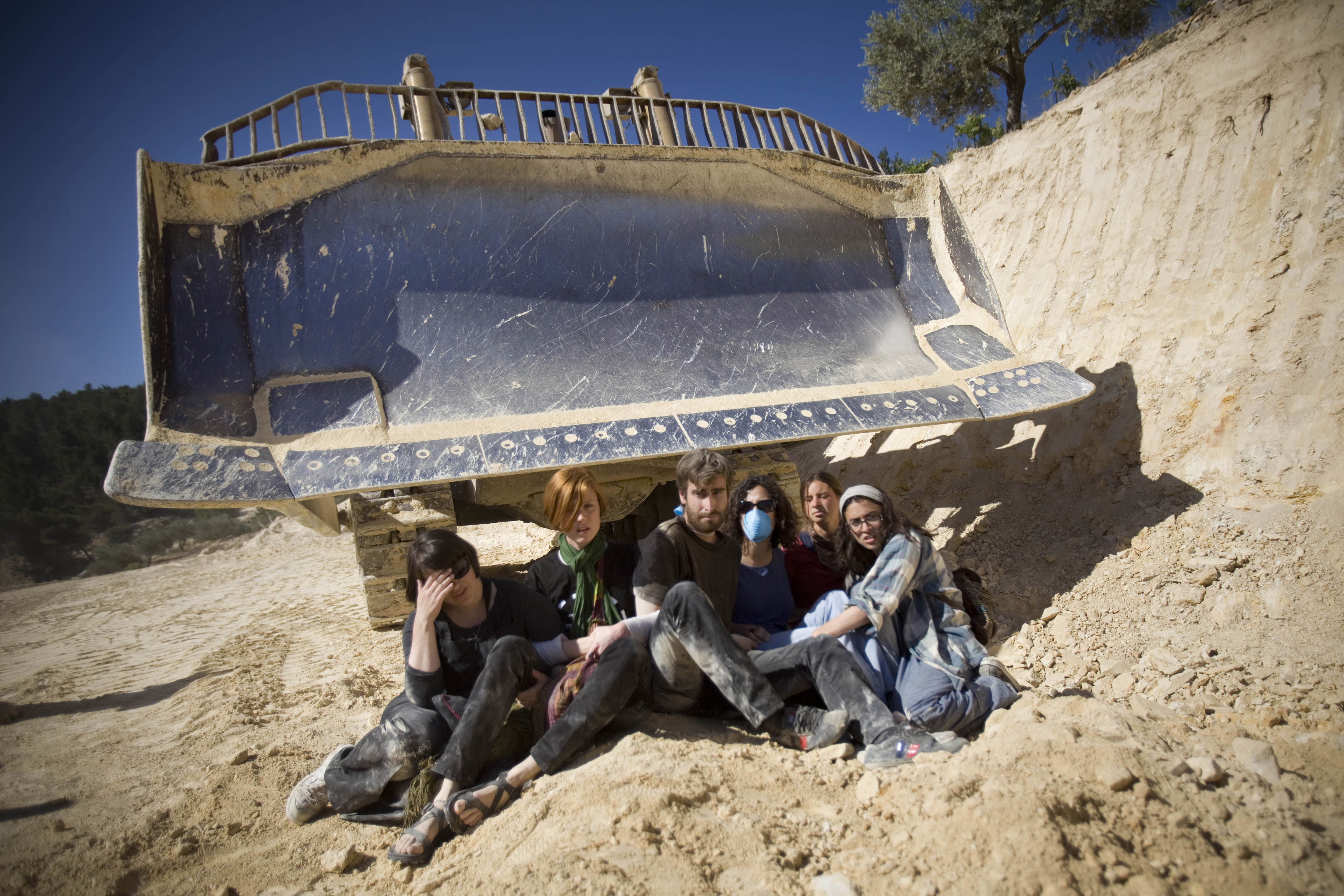 Israeli and international activists sit in front of a bulldozer during a protest against the construction of Israel’s separation barrier in the occupied West Bank village of al-Walaja in 2011