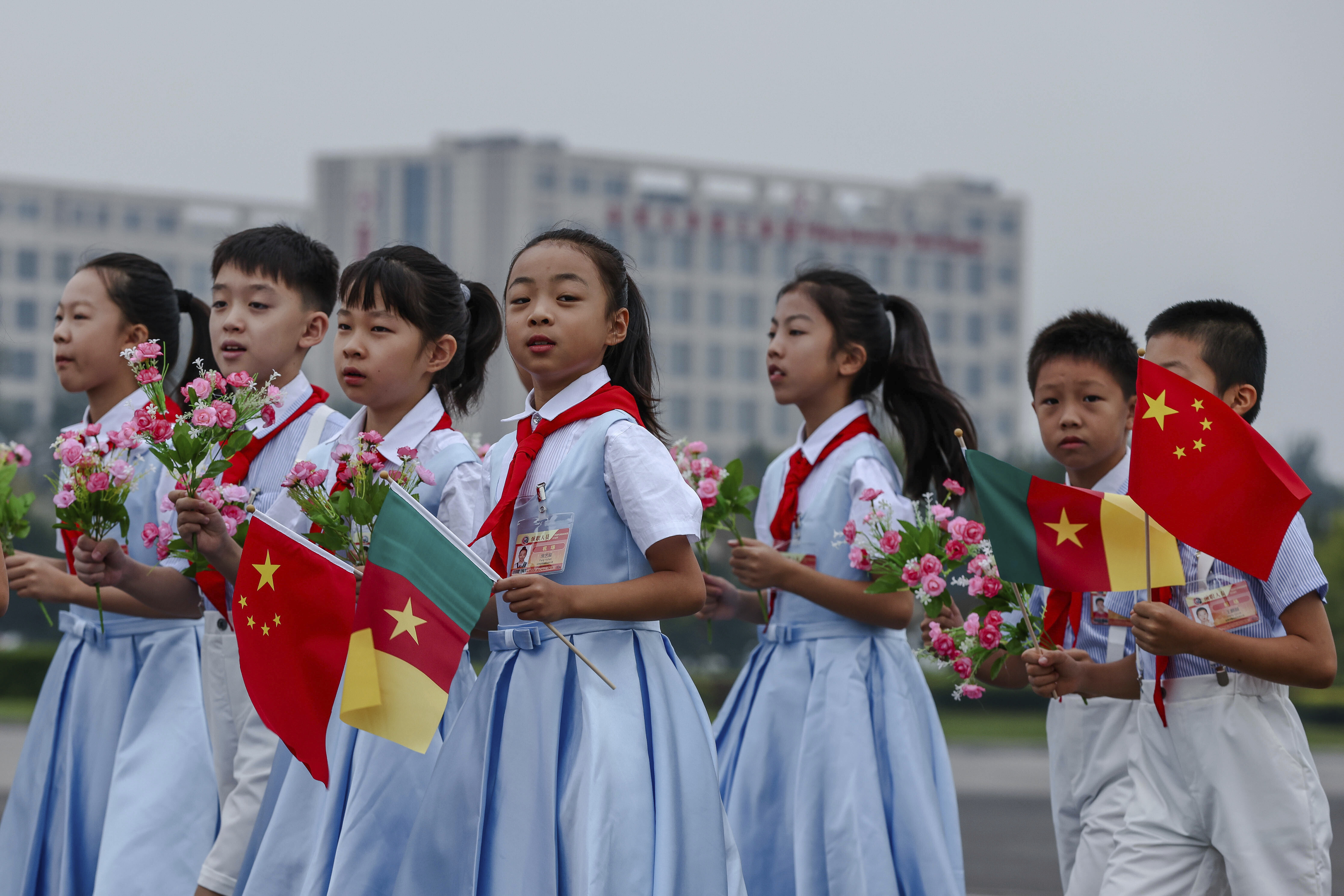 Chinese children prepare for the arrival of Cameroon's President Paul Biya at the Beijing Capital International Airport, ahead of the 2024 Summit of the Forum on China-Africa Cooperation (FOCAC) in Beijing Wednesday, Sept. 4, 2024. (Wu Hao/Pool Photo via AP)