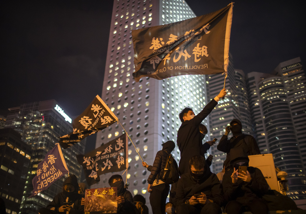 A protester holds a flag that reads, ‘Liberate Hong Kong, Revolution of Our Times’ at a rally in Hong Kong in 2019