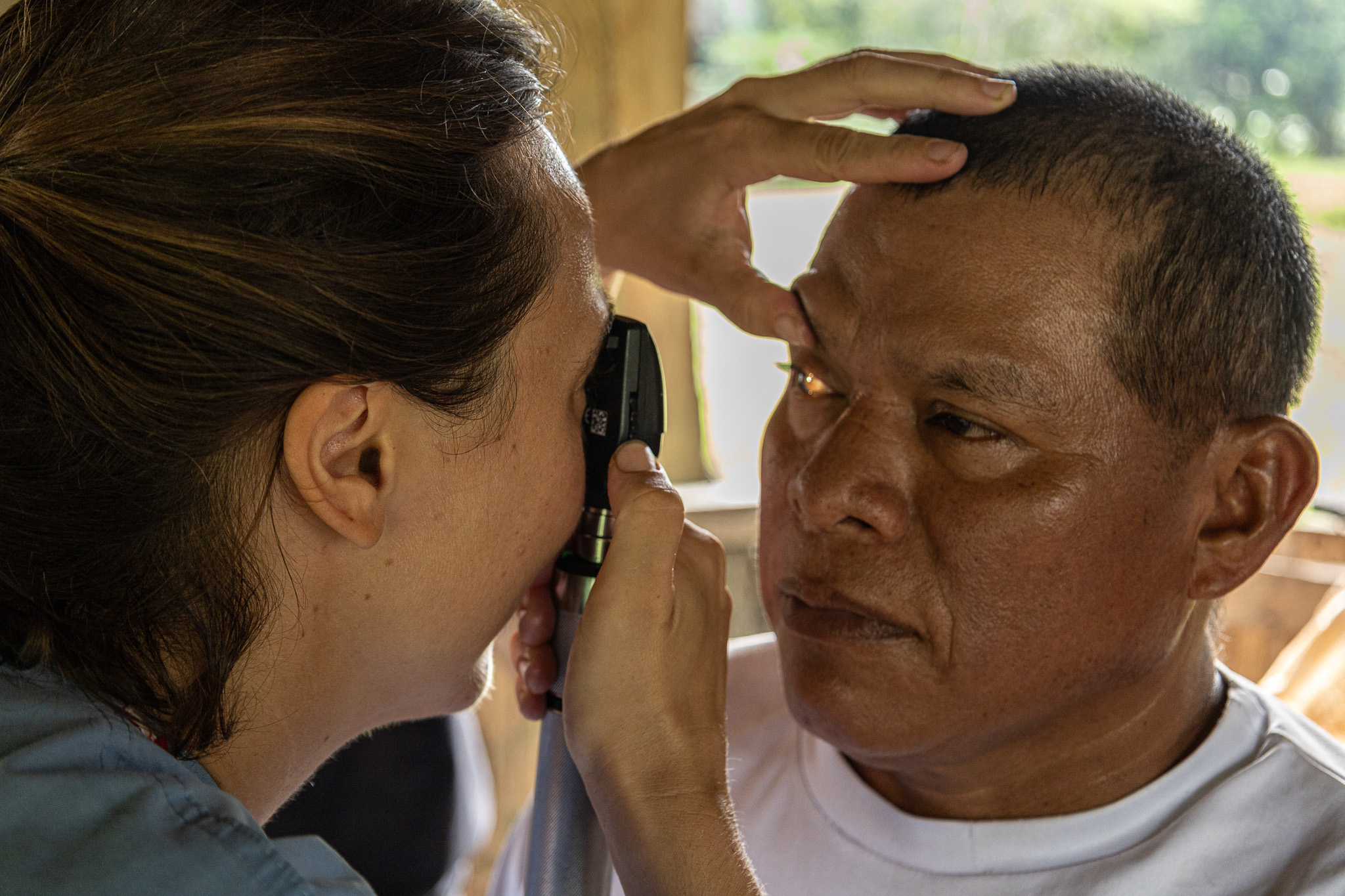 Iris Ertugrul, a Floating Doctors team member from the Netherlands, conducts an eye examination on a Ngabe-Bugle man in La Sabana