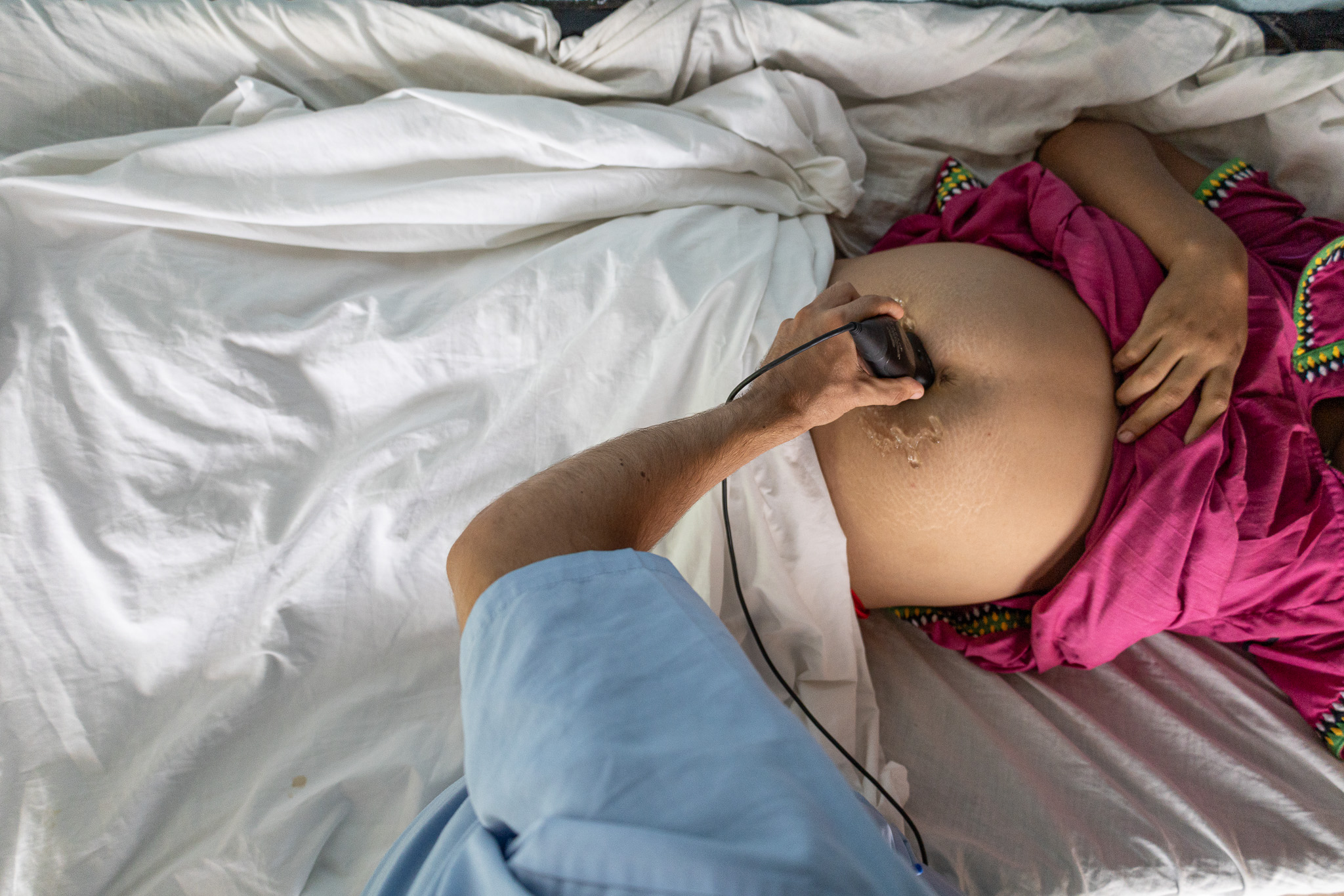 Tomas Santos, a Floating Doctors volunteer from Portugal, conducts an ultrasound on a Ngabe-Bugle woman in a hut in La Sabana
