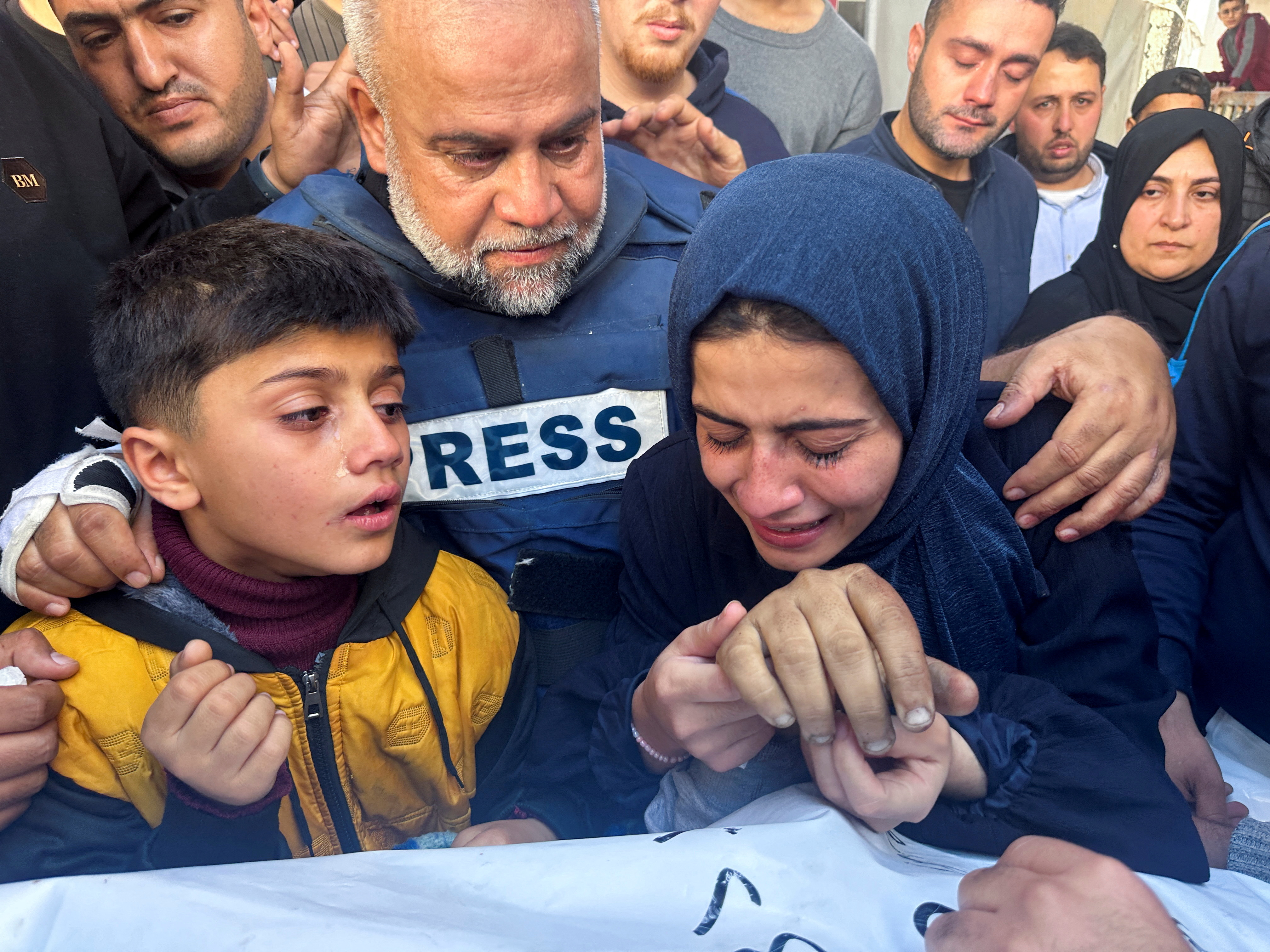 Al Jazeera journalist Wael Al-Dahdouh hugs his daughter and son as they attend the funeral of his son, Palestinian journalist Hamza Al-Dahdouh, after Hamza was killed in an Israeli strike, in Rafah in the southern Gaza Strip, January 7, 2024. [Mohammed Salem/Reuters]