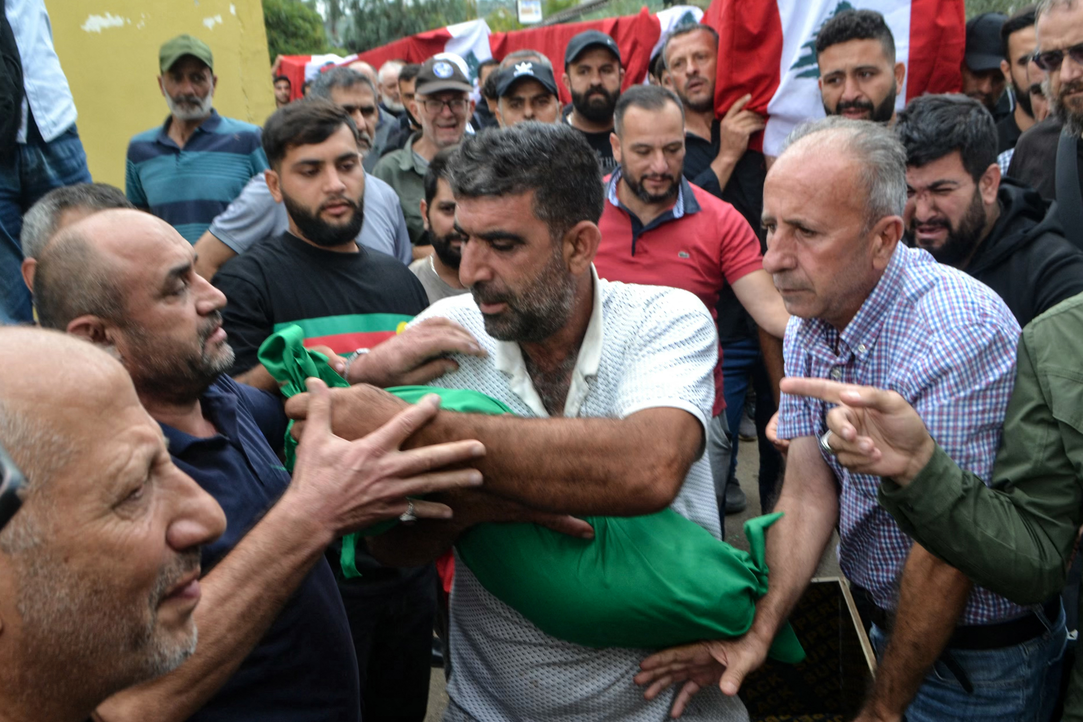 A man carries the shrouded body of a child