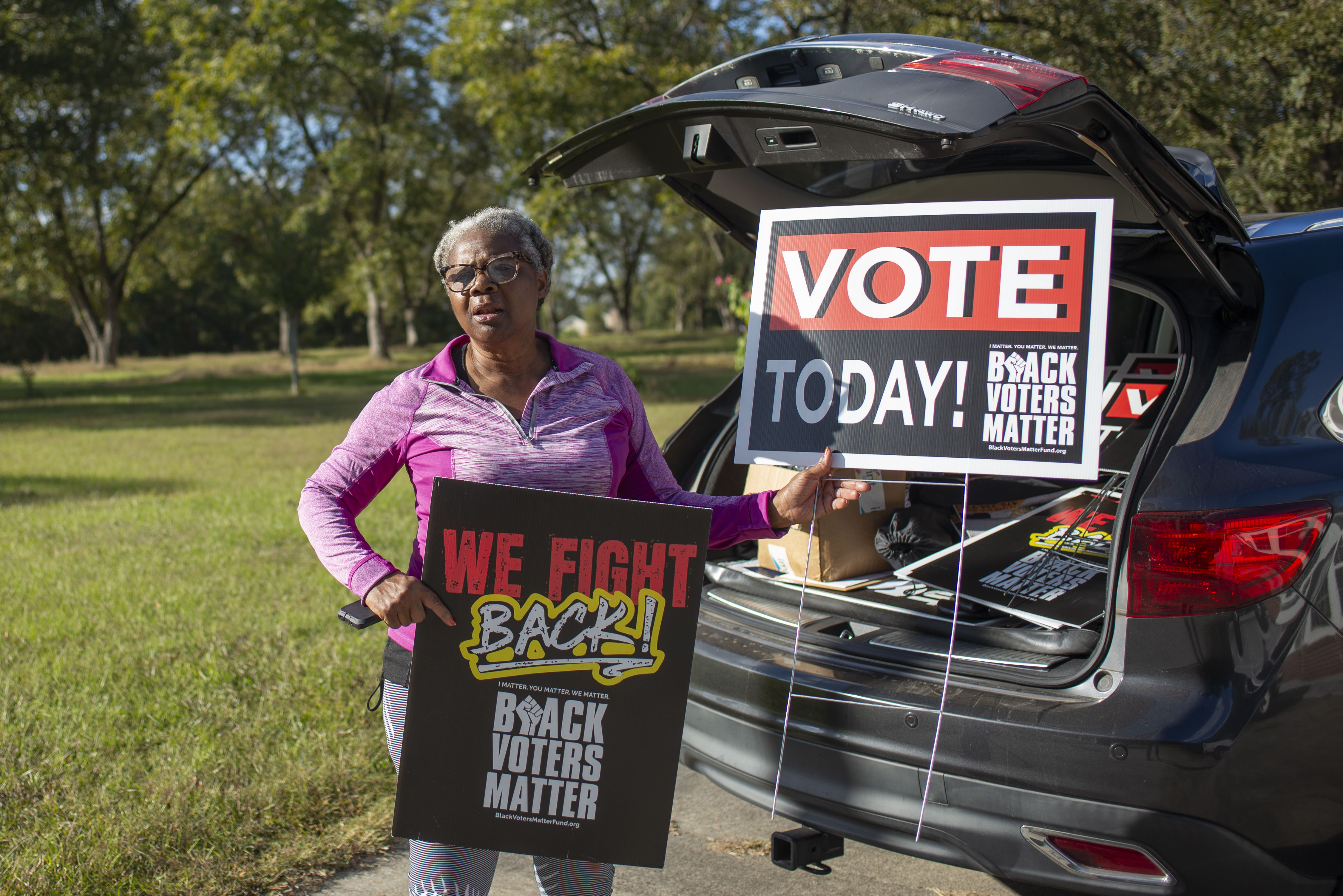 Angela Williams shows off a lawn sign in Peach County, encouraging Black residents to vote