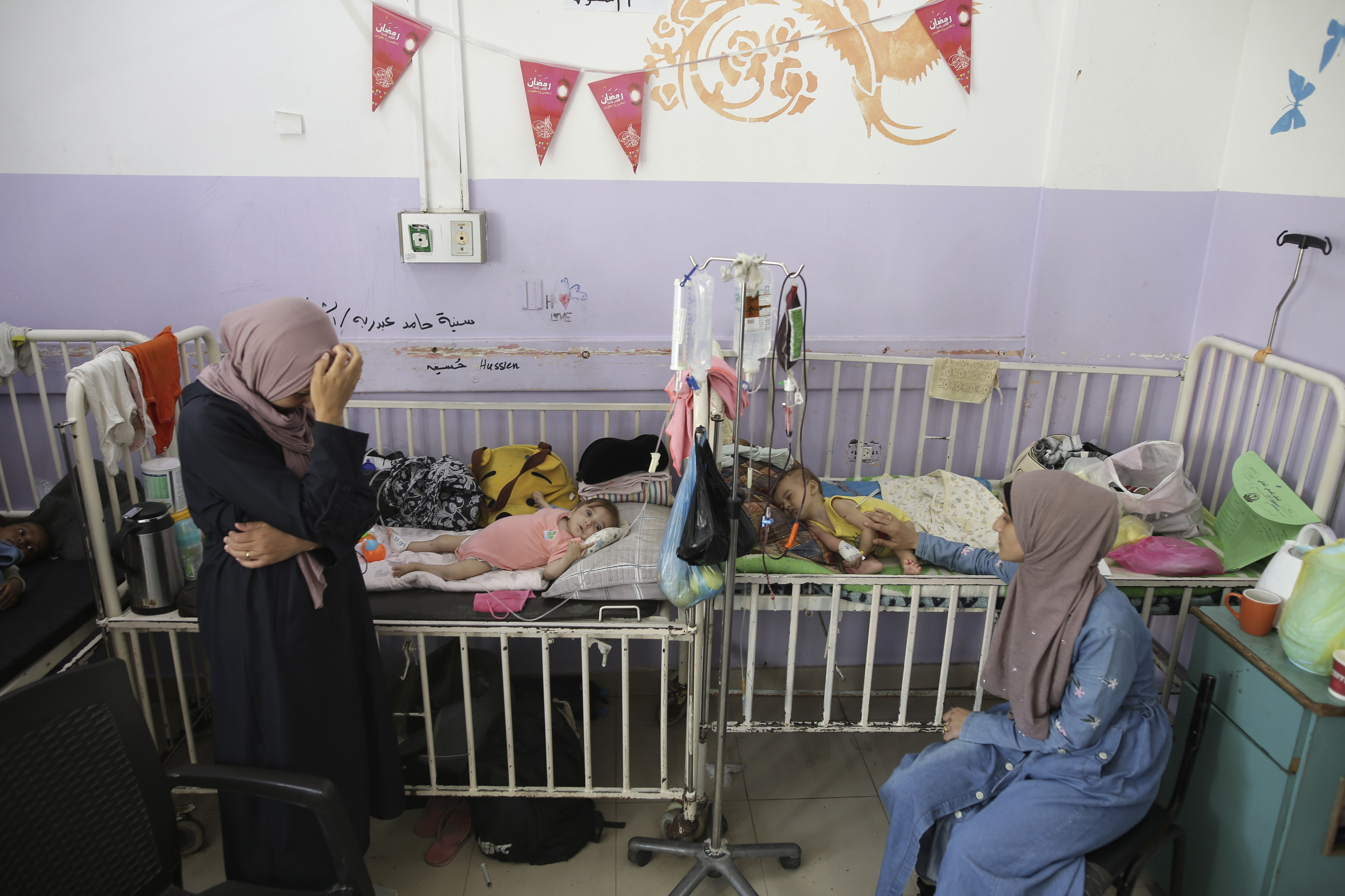 Women sit near their malnourished infants at Al-Aqsa Martyrs Hospital in Deir el-Balah in central Gaza on June 1, 2024
