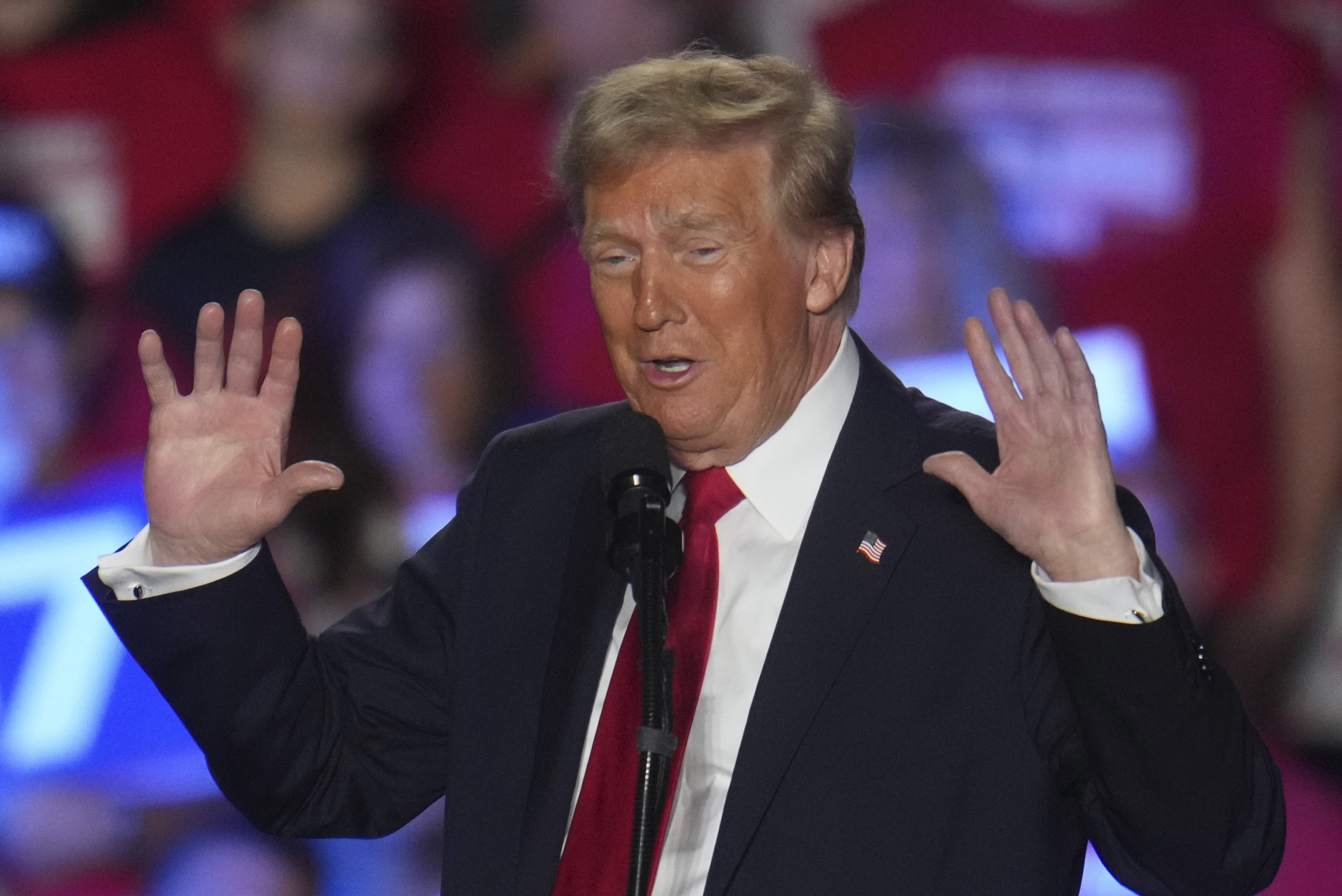 Donald Trump holds up his hands at a rally in Warren Michigan