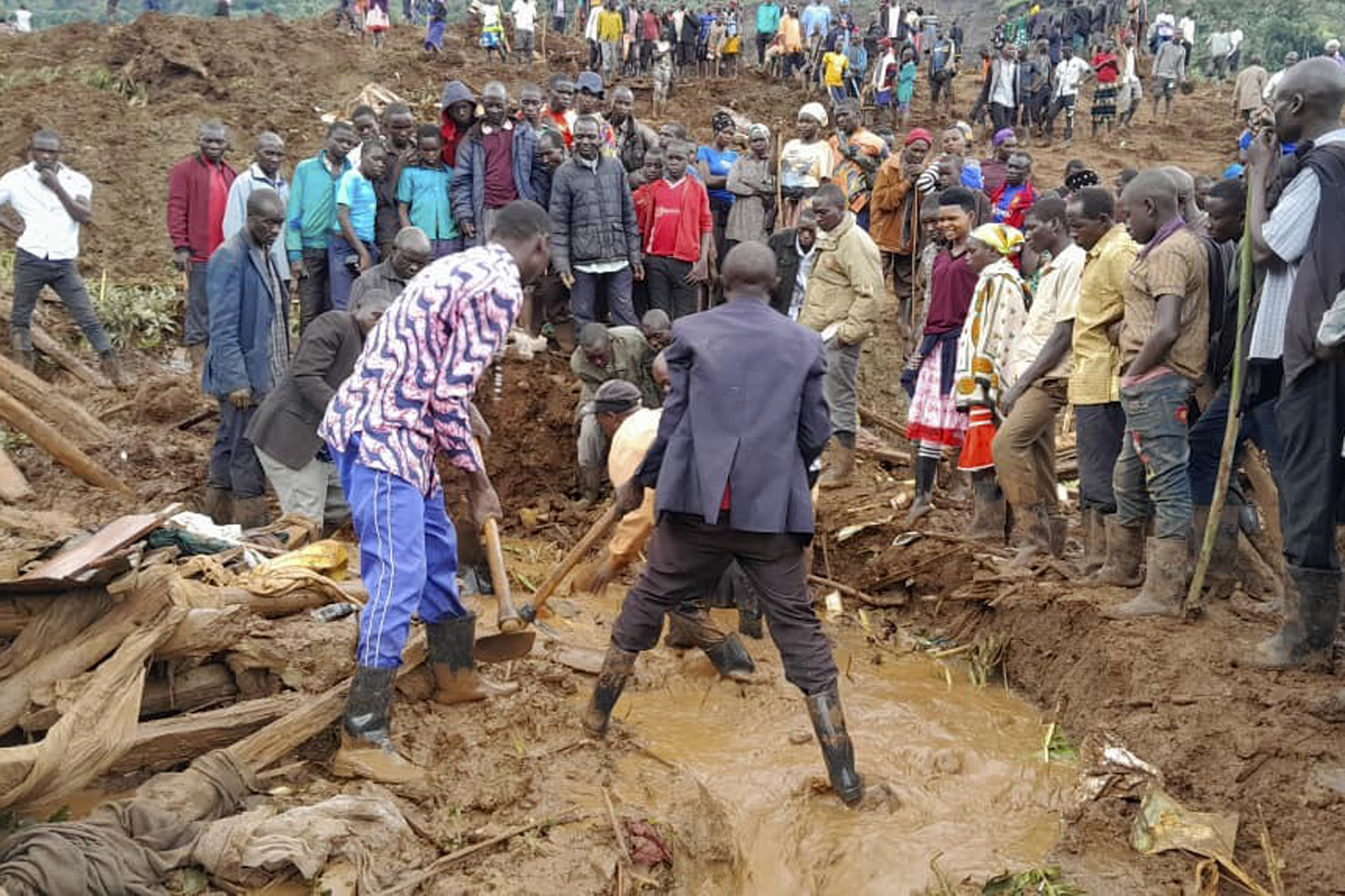 Rescue workers and people search for bodies in the district of Bulambuli, eastern Uganda