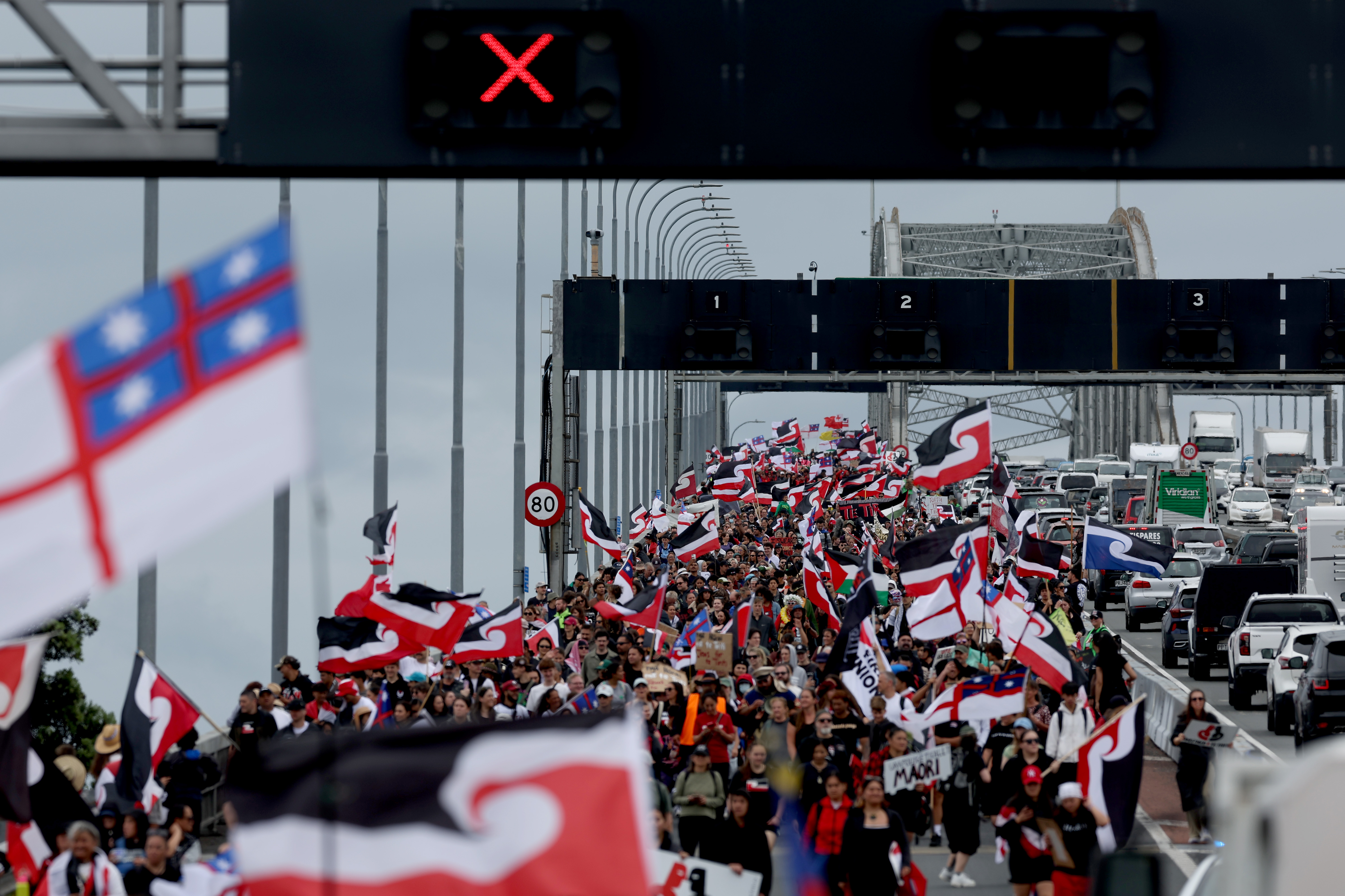 Thousands of marchers protesting government policies that affect the Māori cross the Auckland Harbour Bridge on day three of a nine-day journey to Wellington on November 13, 2024 in Auckland, New Zealand