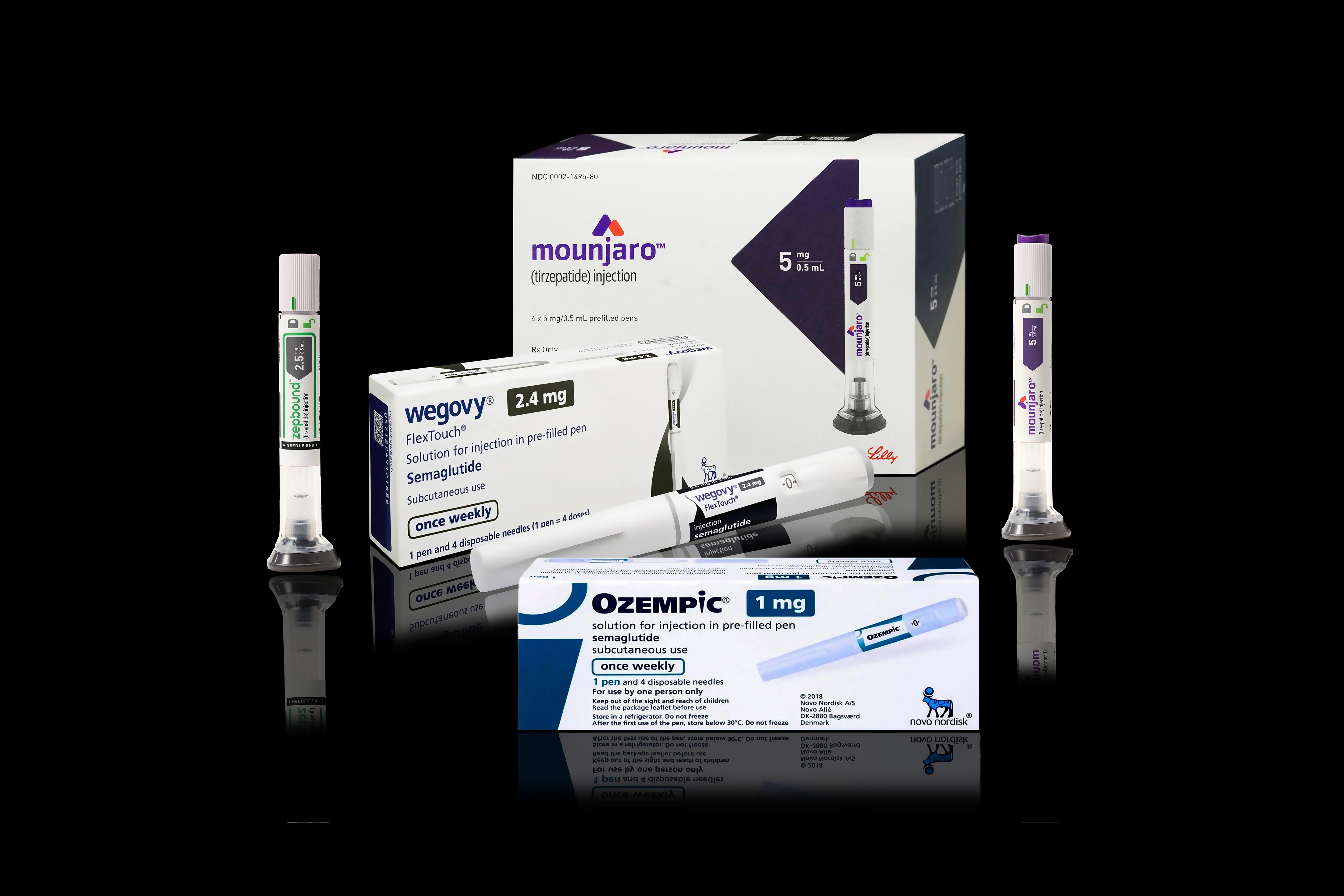 Injection pens and packaging boxes of weight-loss and type 2 diabetes medication Mounjaro, Wegovy, Ozempic, Zepbound Isolated on black background with reflections. Copenhagen, Denmark - May 8, 2024.
