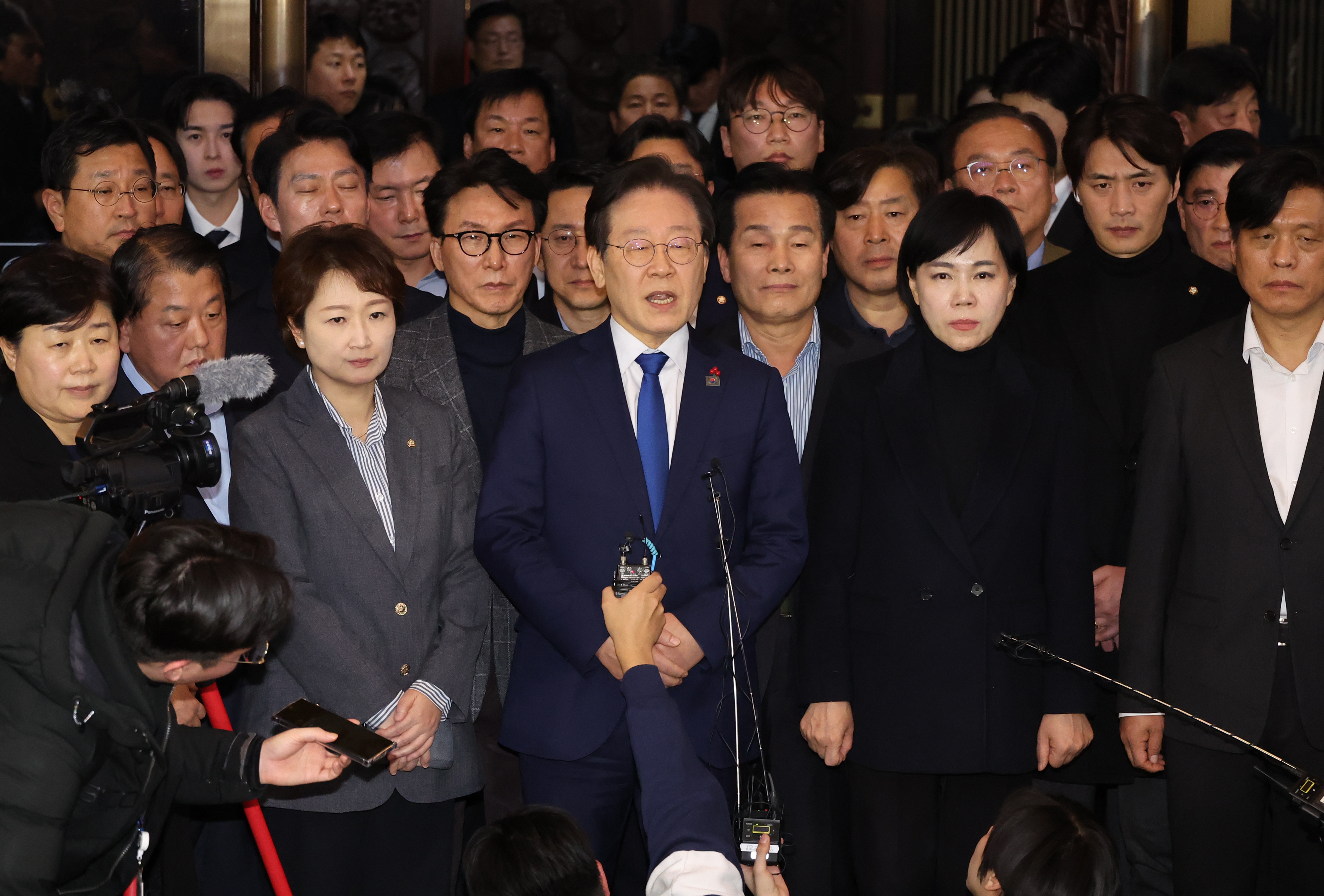 Democratic Party leader Lee Jae-myung (C) announces his stance at the National Assembly in Seoul [Yonhap via EPA]