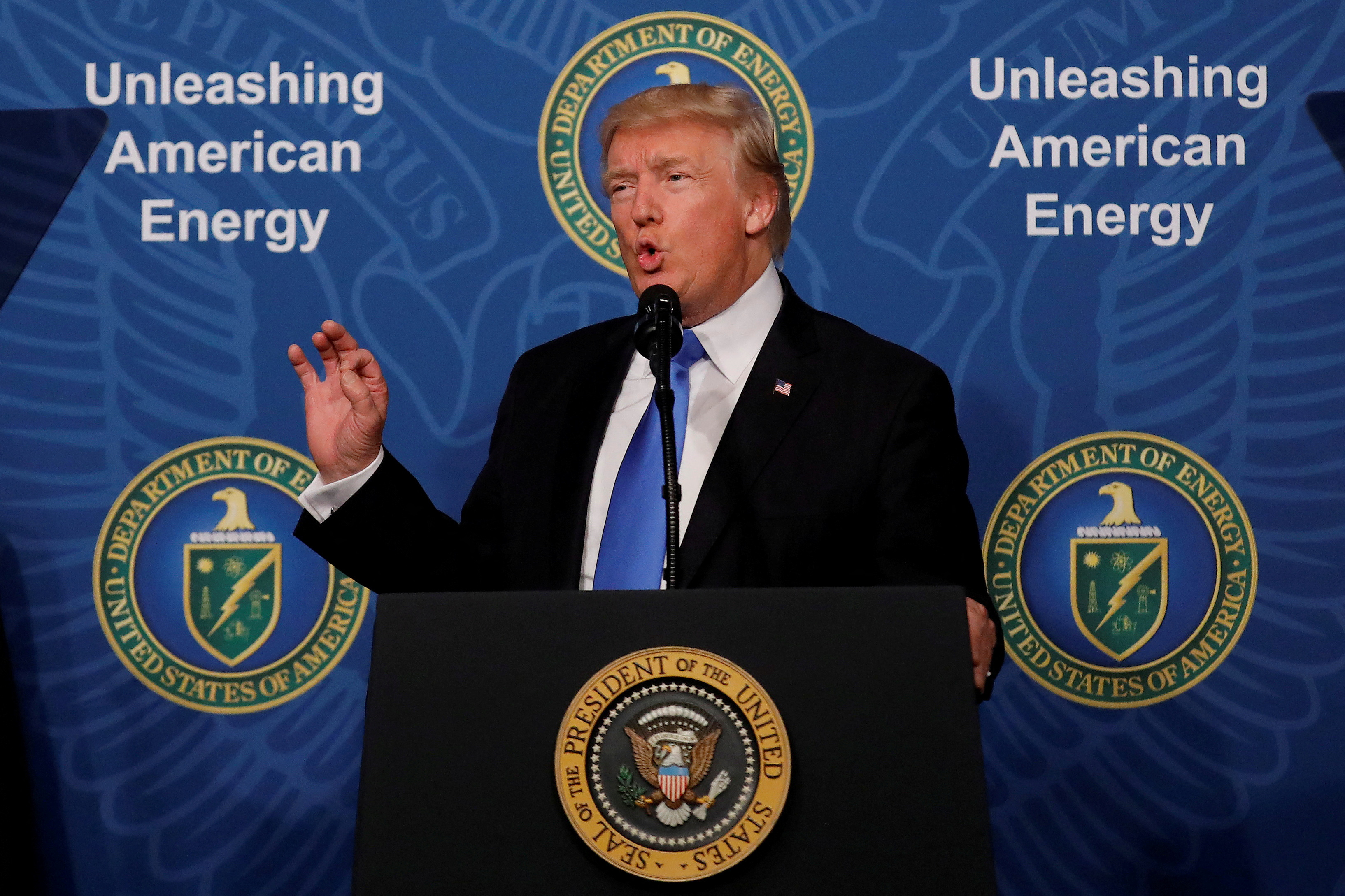 Donald Trump speaks ata podium in front of a sign that reads, "Unleashing American Energy."
