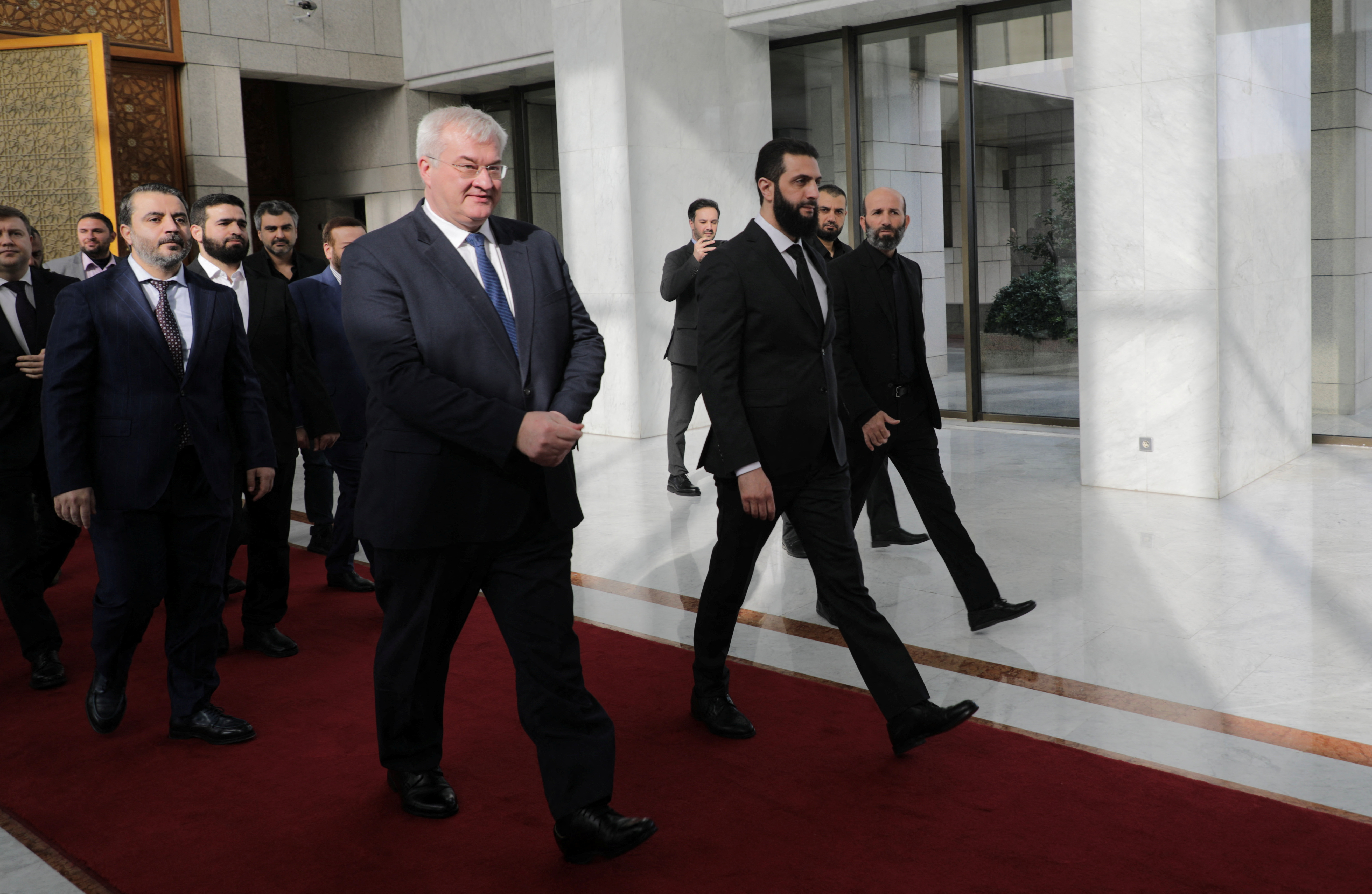 Syria's de facto leader Ahmed al-Sharaa, also known as Abu Mohammed al-Golani walks as he meets with senior Ukrainian delegation led by Ukrainian Foreign Minister Andrii Sybiha