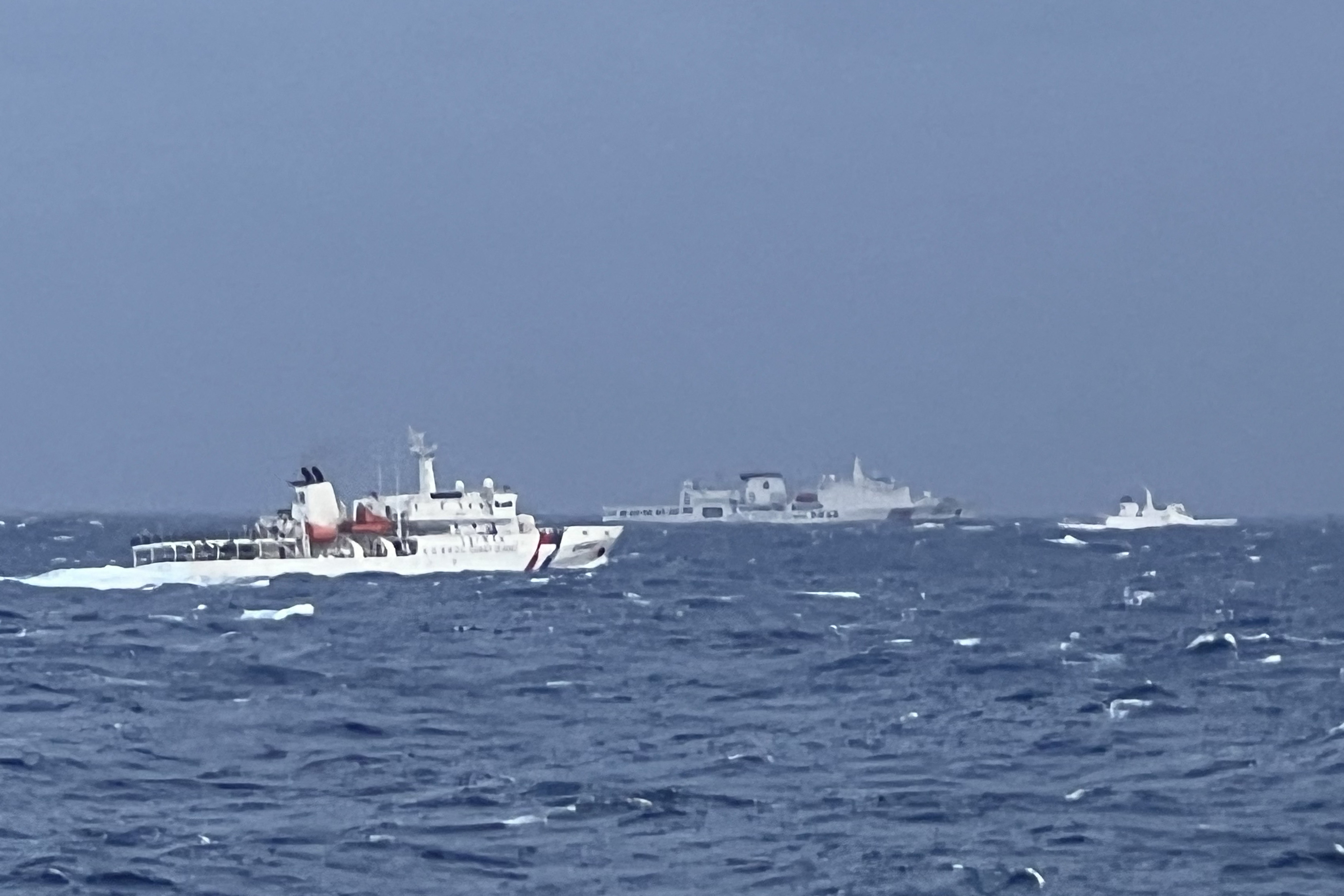 A Chinese coastguard ship, centre, is seen past Taiwan coastguard vessels in waters east of Taiwan