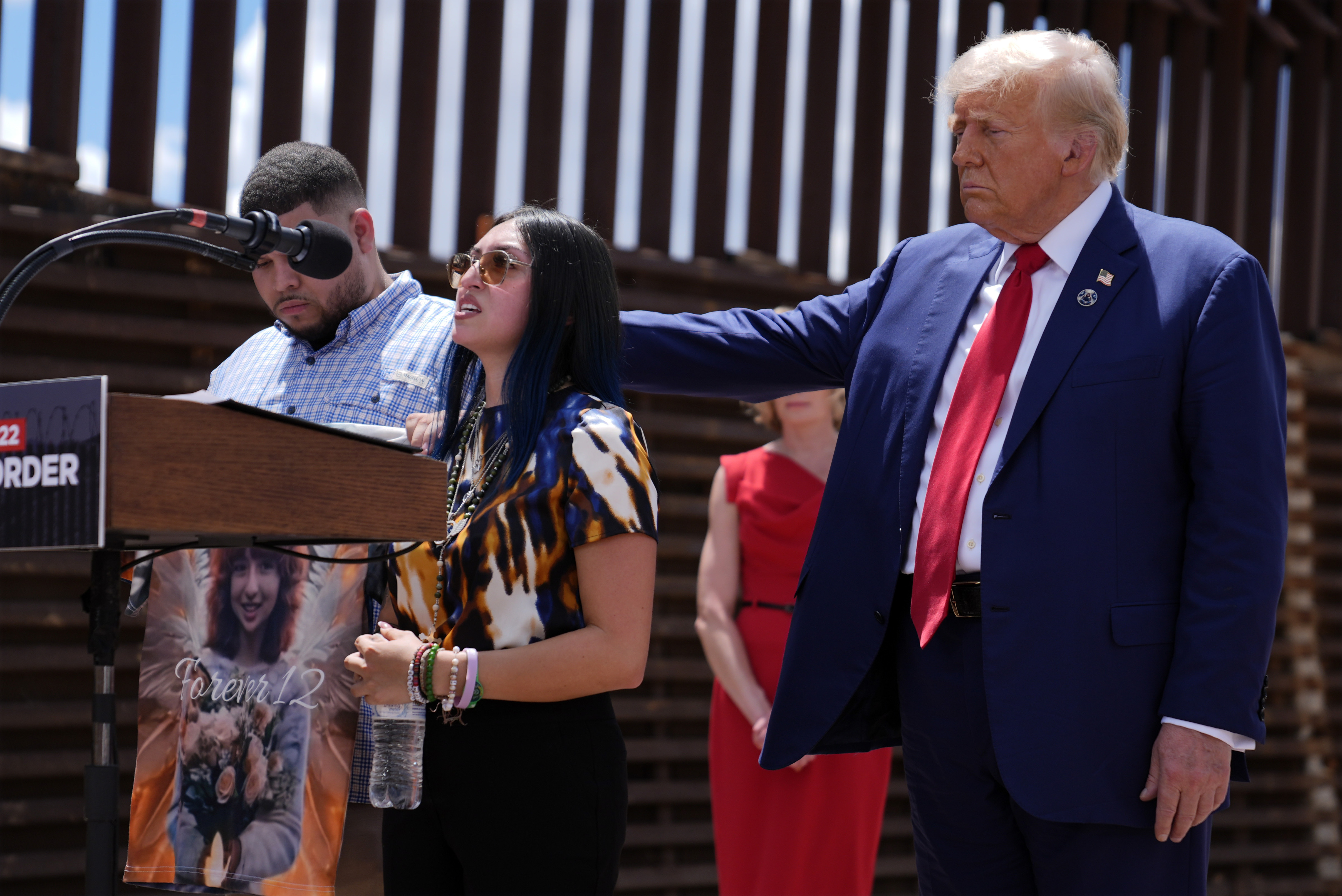 Donald Trump puts a hand on Alexis Nungaray's shoulder as she speaks in front of the US-Mexico border wall
