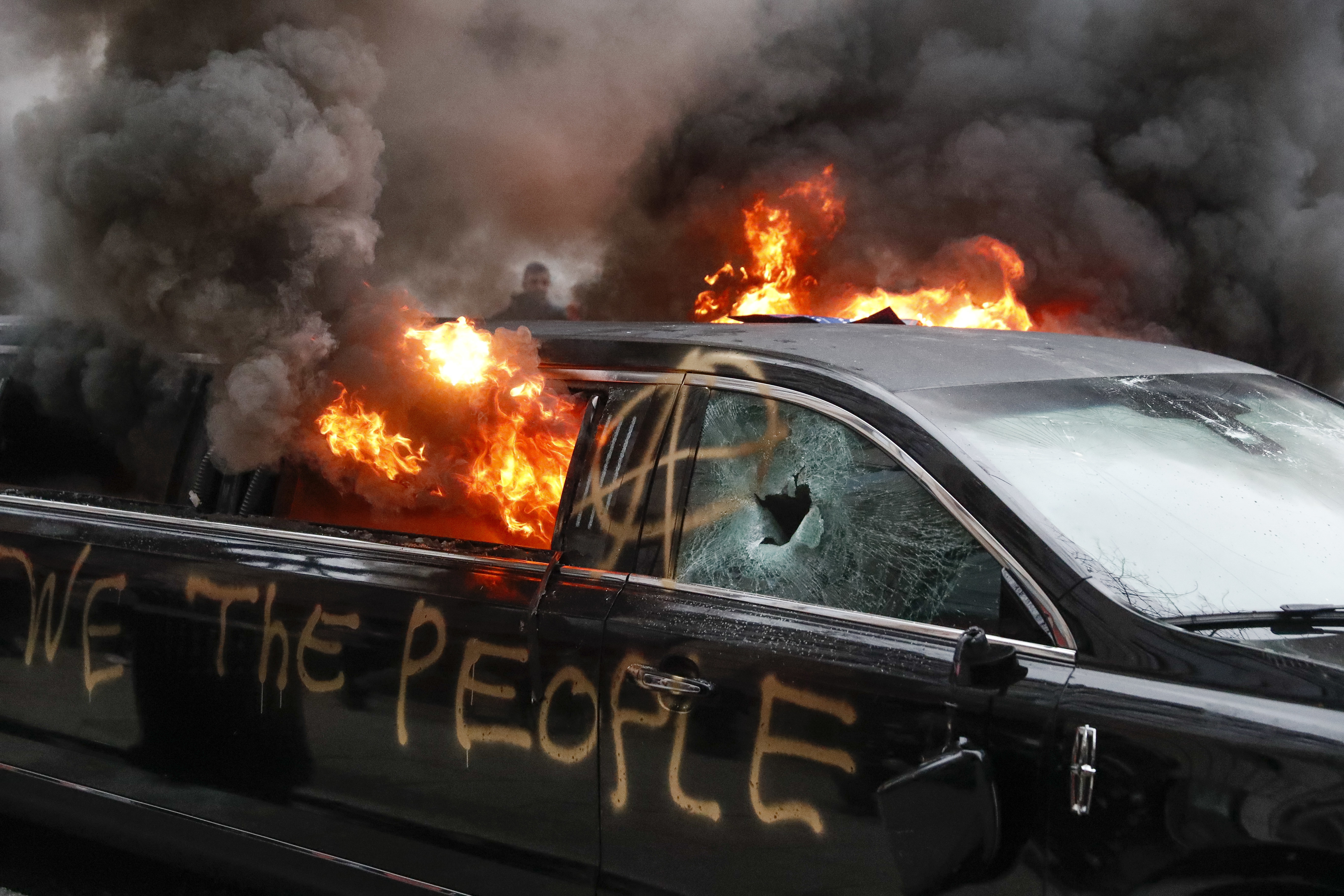 A limousine spray-painted with graffiti burns in downtown Washington, DC, in 2017