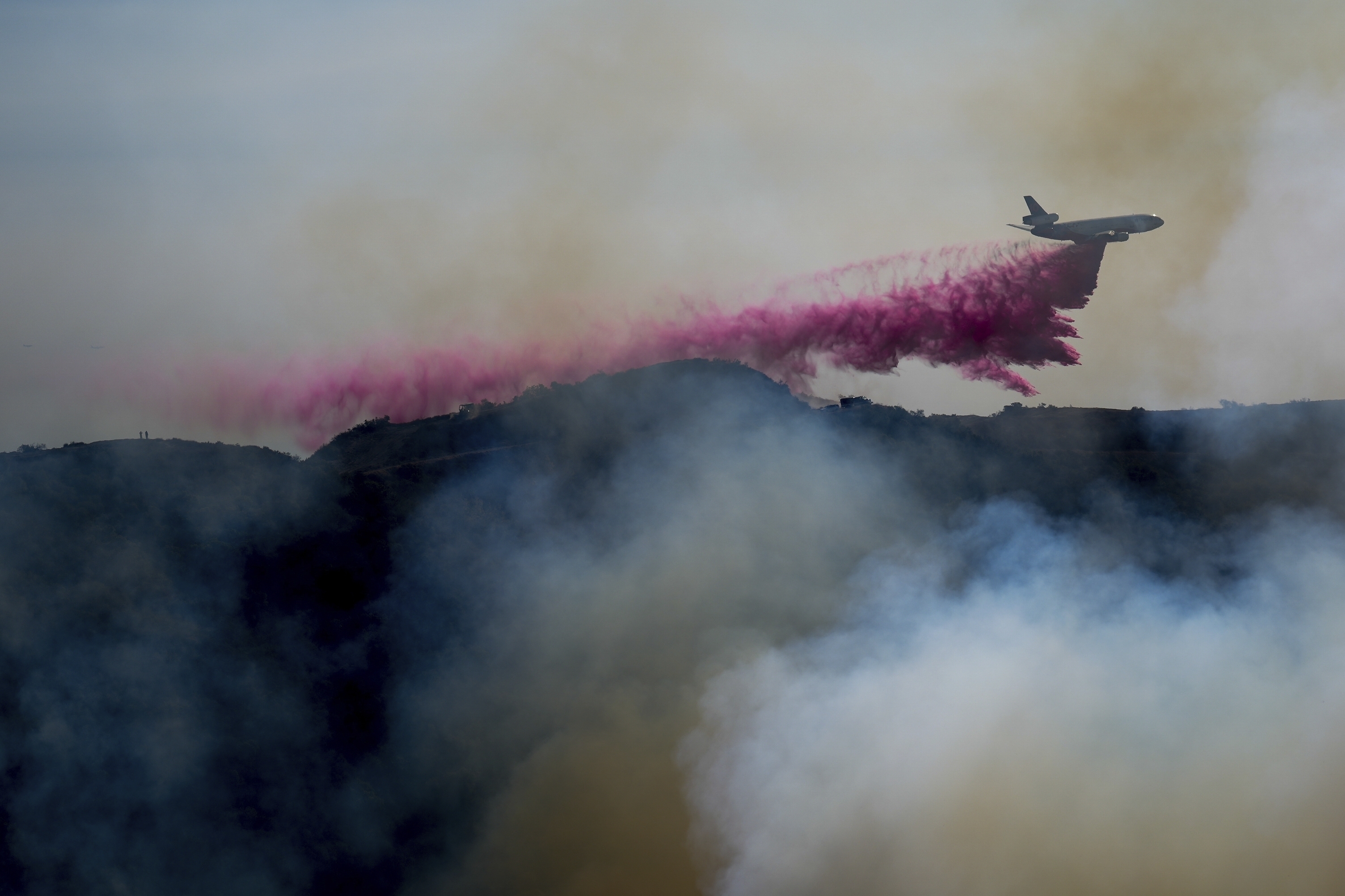 A plane drops pink fire retardant on California wildfires