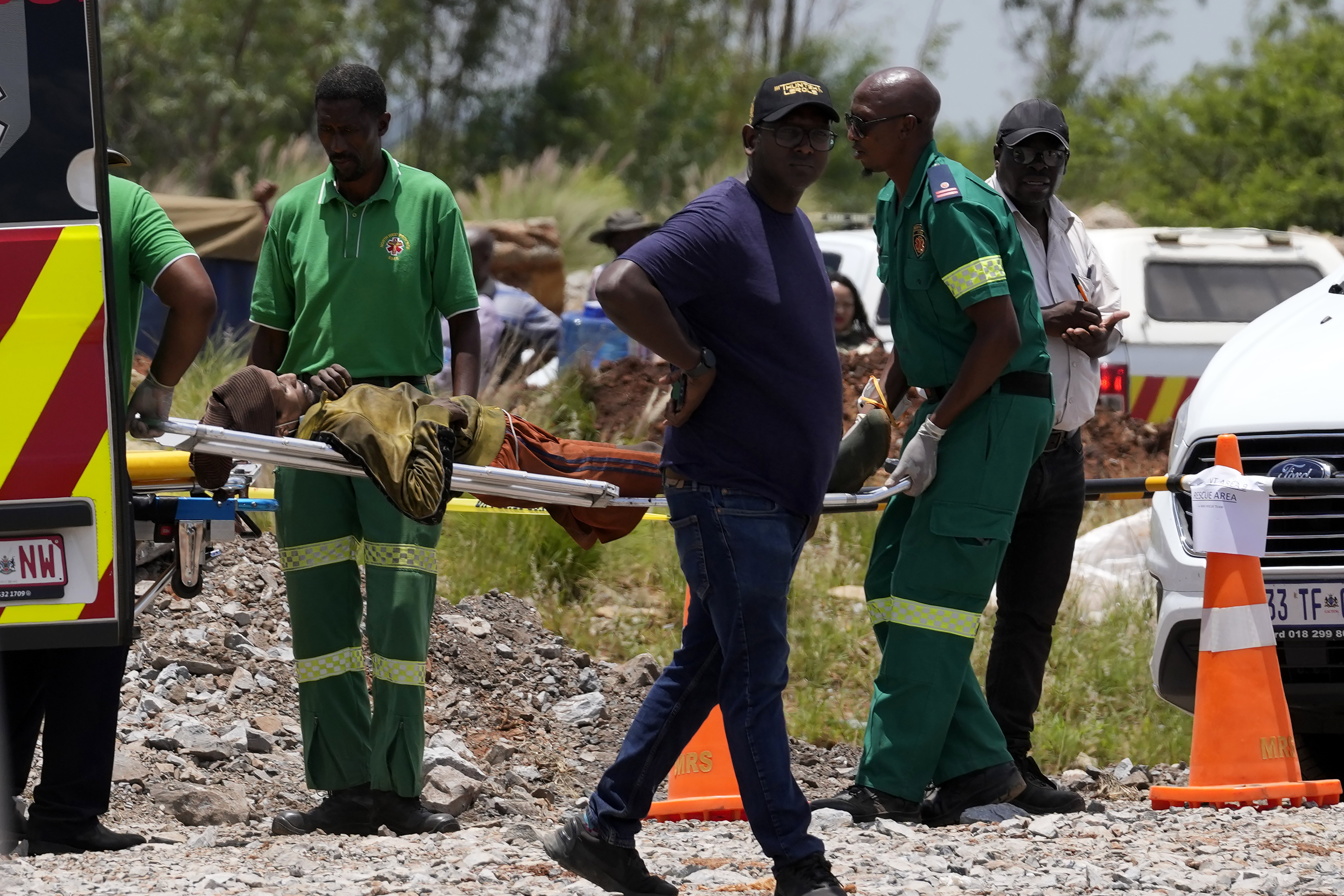 A miner is transported on a stretcher by rescue workers.