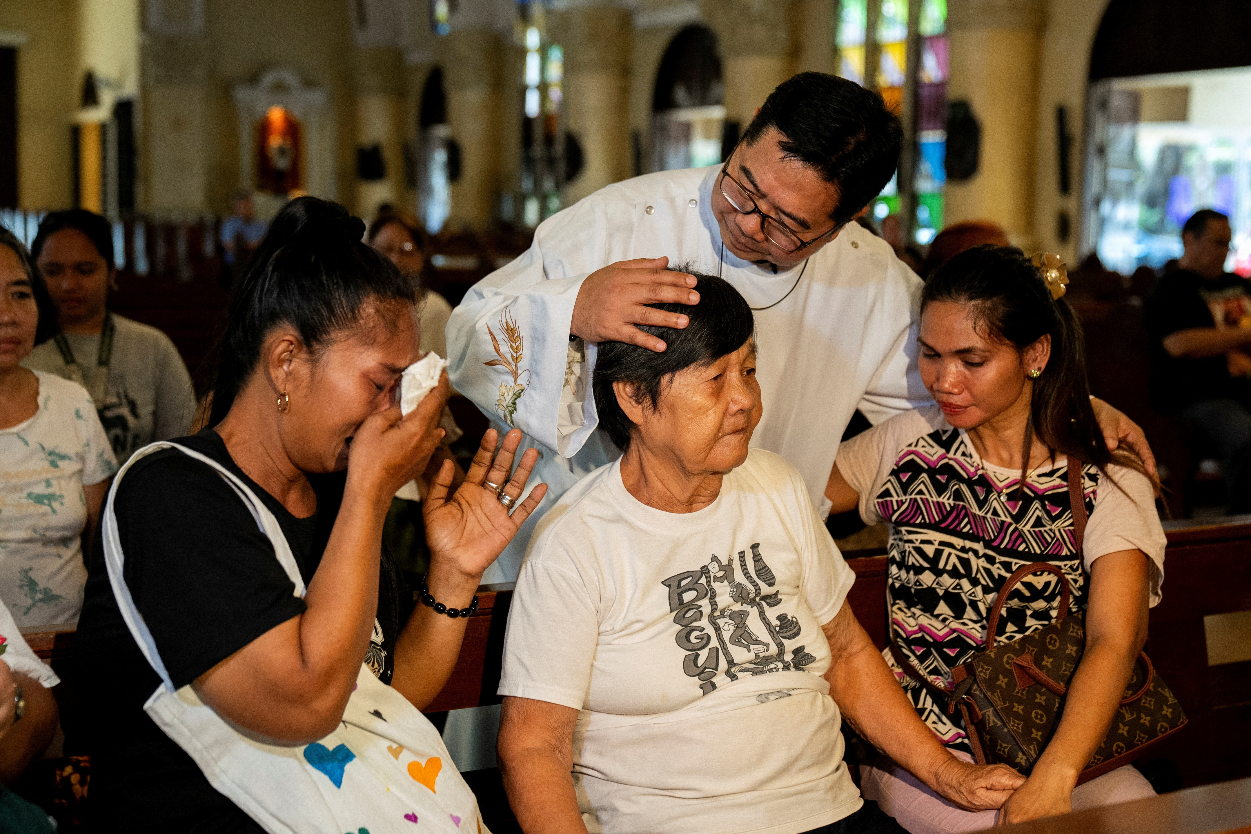 Catholic priest Flavie Villanueva comforts relatives of victims of drug war and extrajudicial killings, before a mass following the arrest of former Philippine President Rodrigo Duterte, in Quezon City, Philippines, March 11, 2025. REUTERS/Lisa Marie David TPX IMAGES OF THE DAY