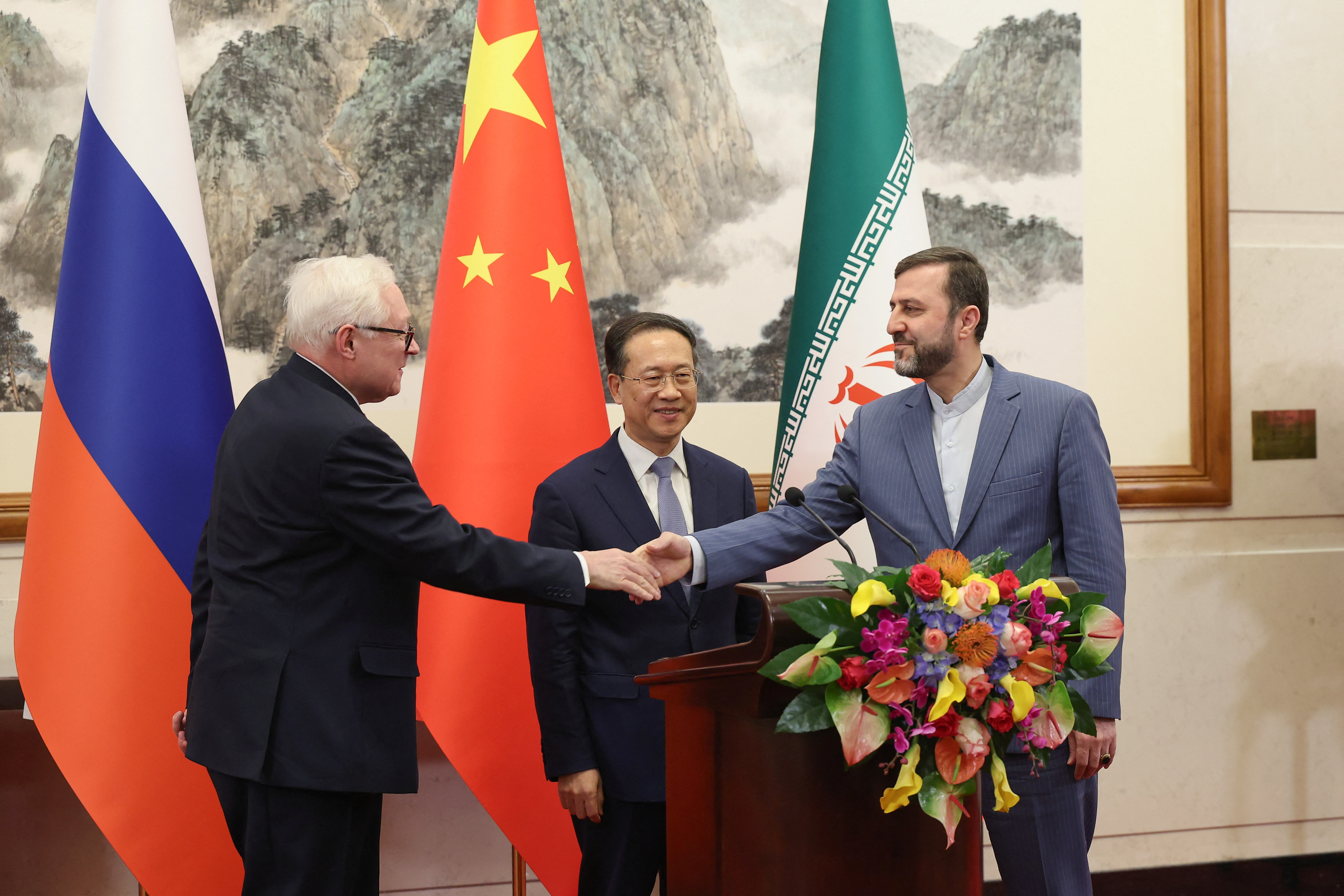 Russian Deputy Foreign Minister Sergei Ryabkov and and Iranian Deputy Foreign Minister Kazem Gharibabadi shake hands as Chinese Vice Foreign Minister Ma Zhaoxu looks on during their meet with reporters after their meeting at Diaoyutai State Guest House on March 14, 2025 in Beijing, China. Lintao Zhang/Pool via REUTERS