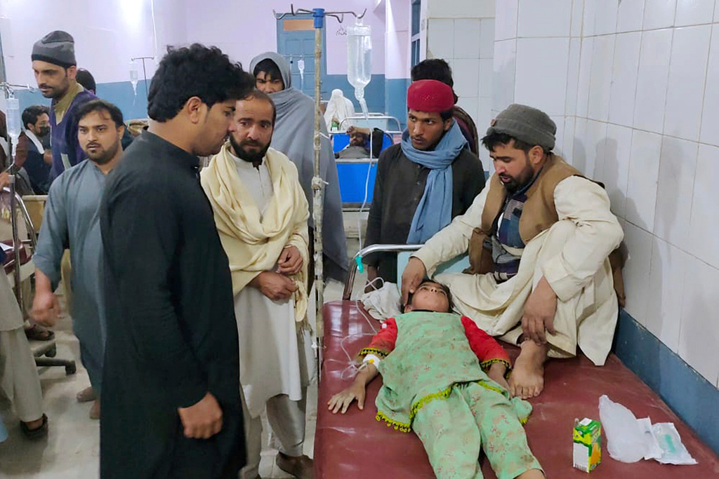 Family members stand around a girl injured in the bomb explosion as she receives treatment at a hospital in Bannu, northwest Pakistan
