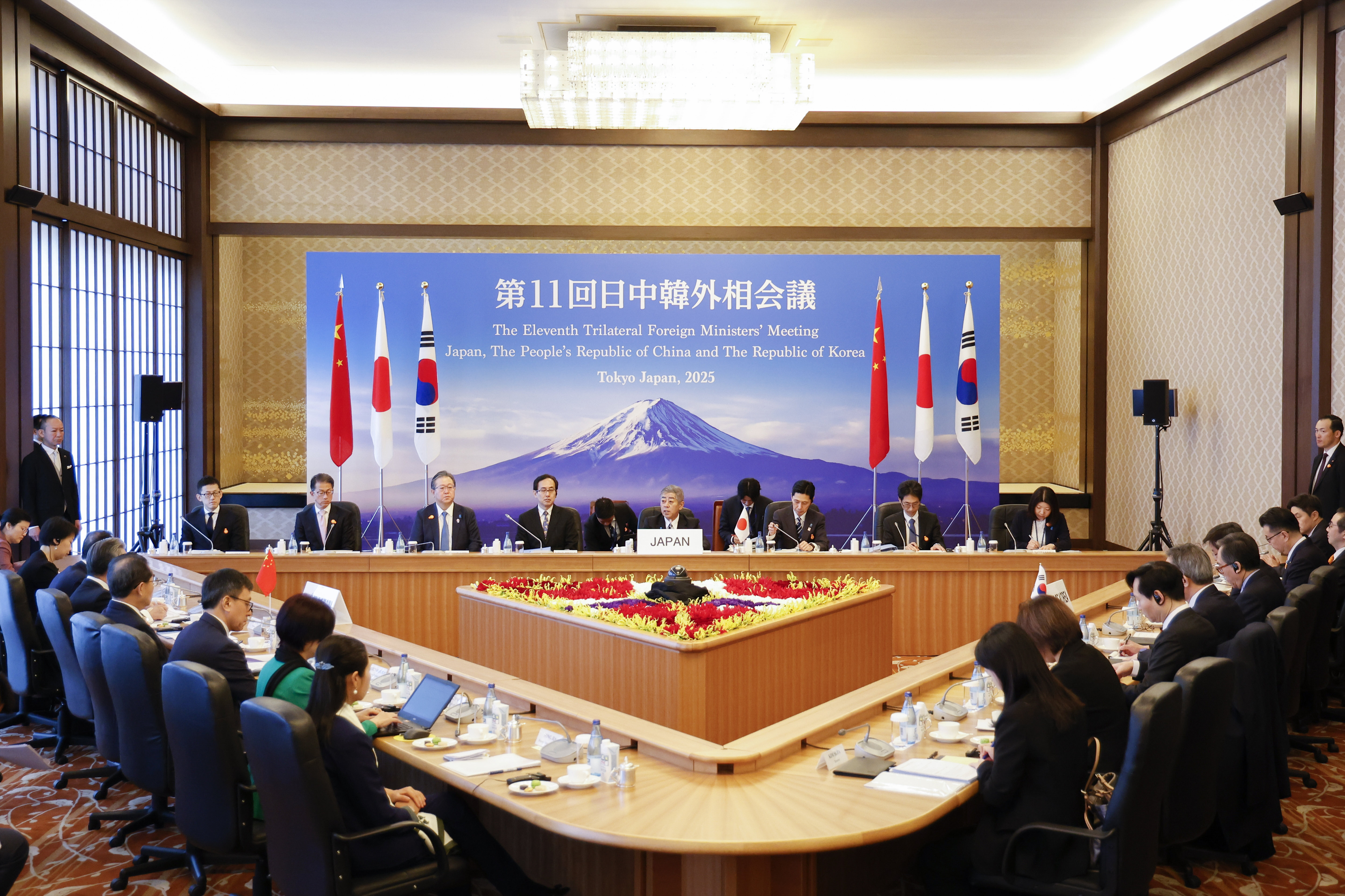 Japanese Foreign Minister Takeshi Iwaya, center, welcomes Chinese Foreign Minister Wang Yi and the South Korean Foreign Minister Cho Tae-yul