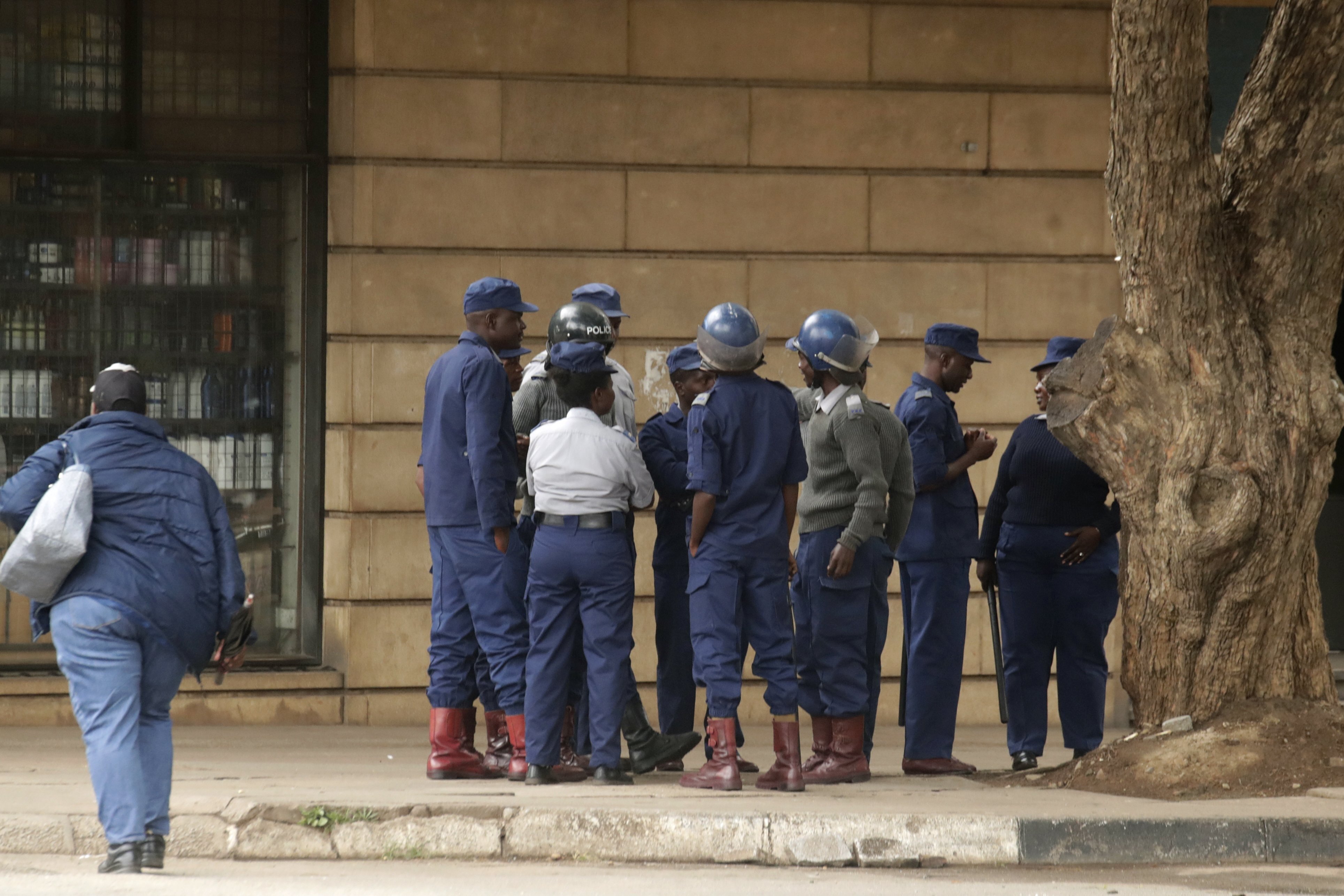 Riot police officers gather on a deserted street in downtown Harare, Zimbabwe, on Monday, March 31, 2025, following calls for an antigovernment protest