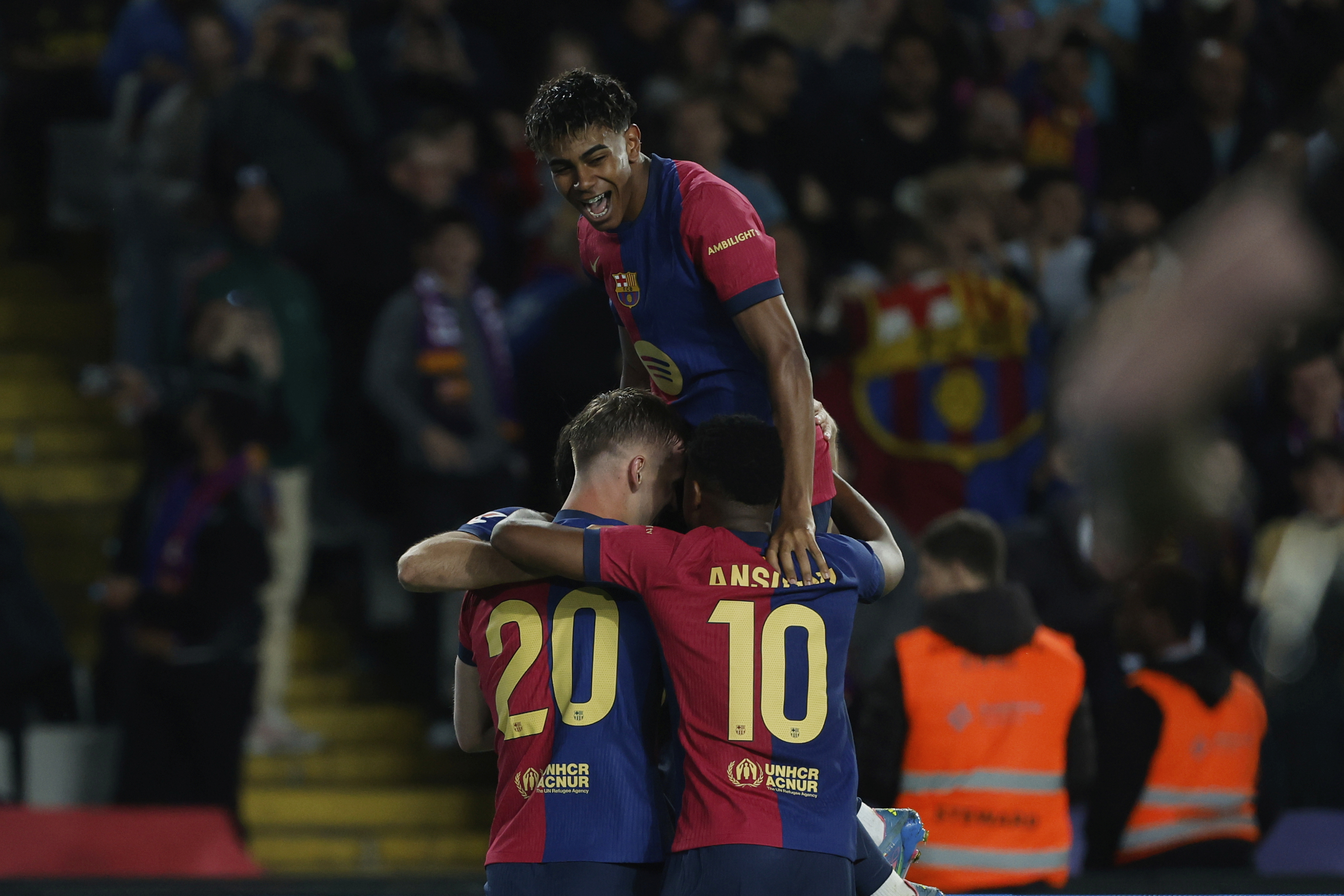Barcelona's Dani Olmo, left, celebrates with his teammates after scoring his side's opening goal during a Spanish La Liga soccer match between Barcelona and Mallorca at the Lluis Companys Olympic stadium in Barcelona, Spain, Tuesday, April 22, 2025. (AP Photo/Joan Monfort)
