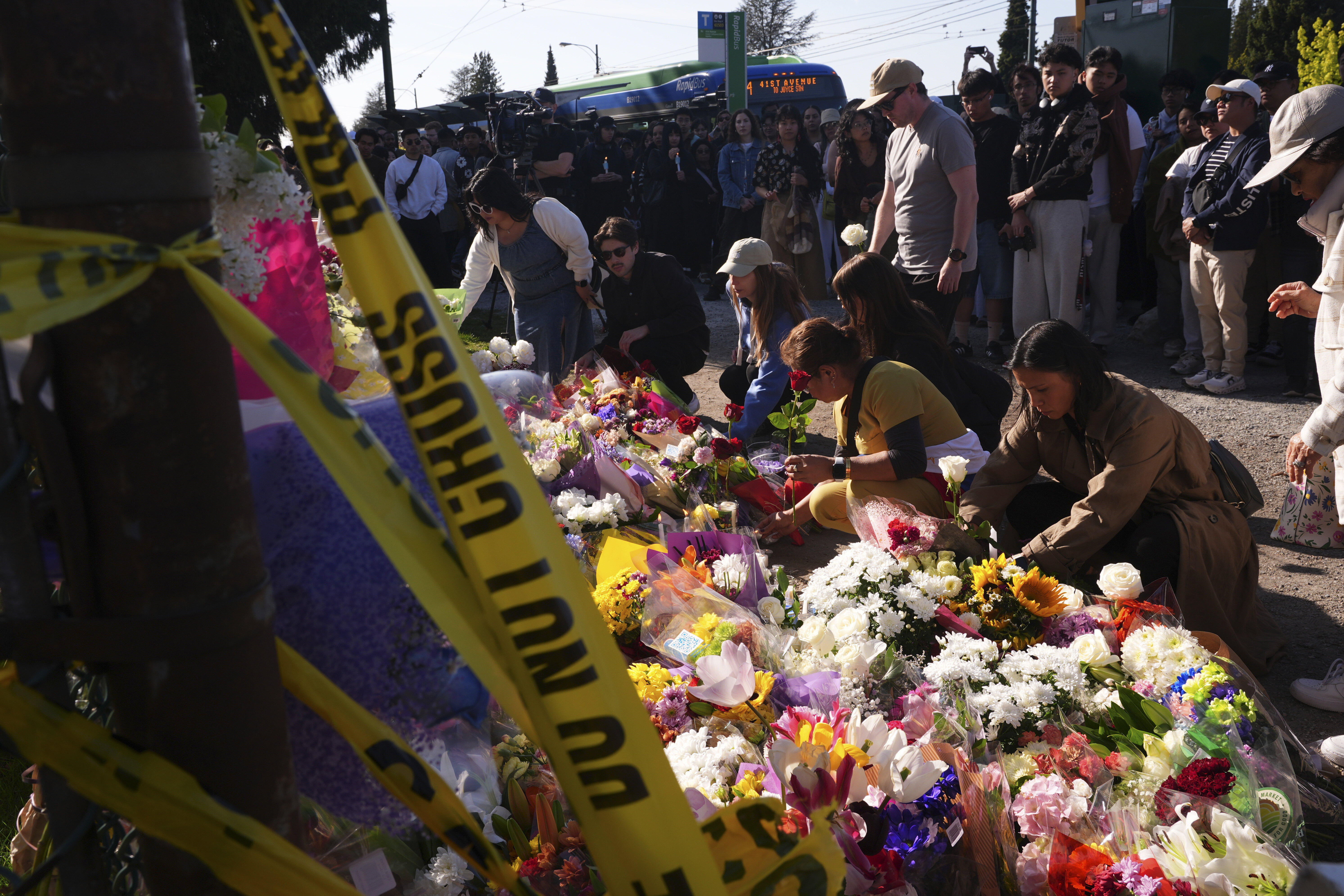 Visitors pay their respects at a memorial after a vehicle drove into a crowd during a Filipino heritage festival in Vancouver, British Columbia, Sunday, April 27, 2025. (AP Photo/Lindsey Wasson)
