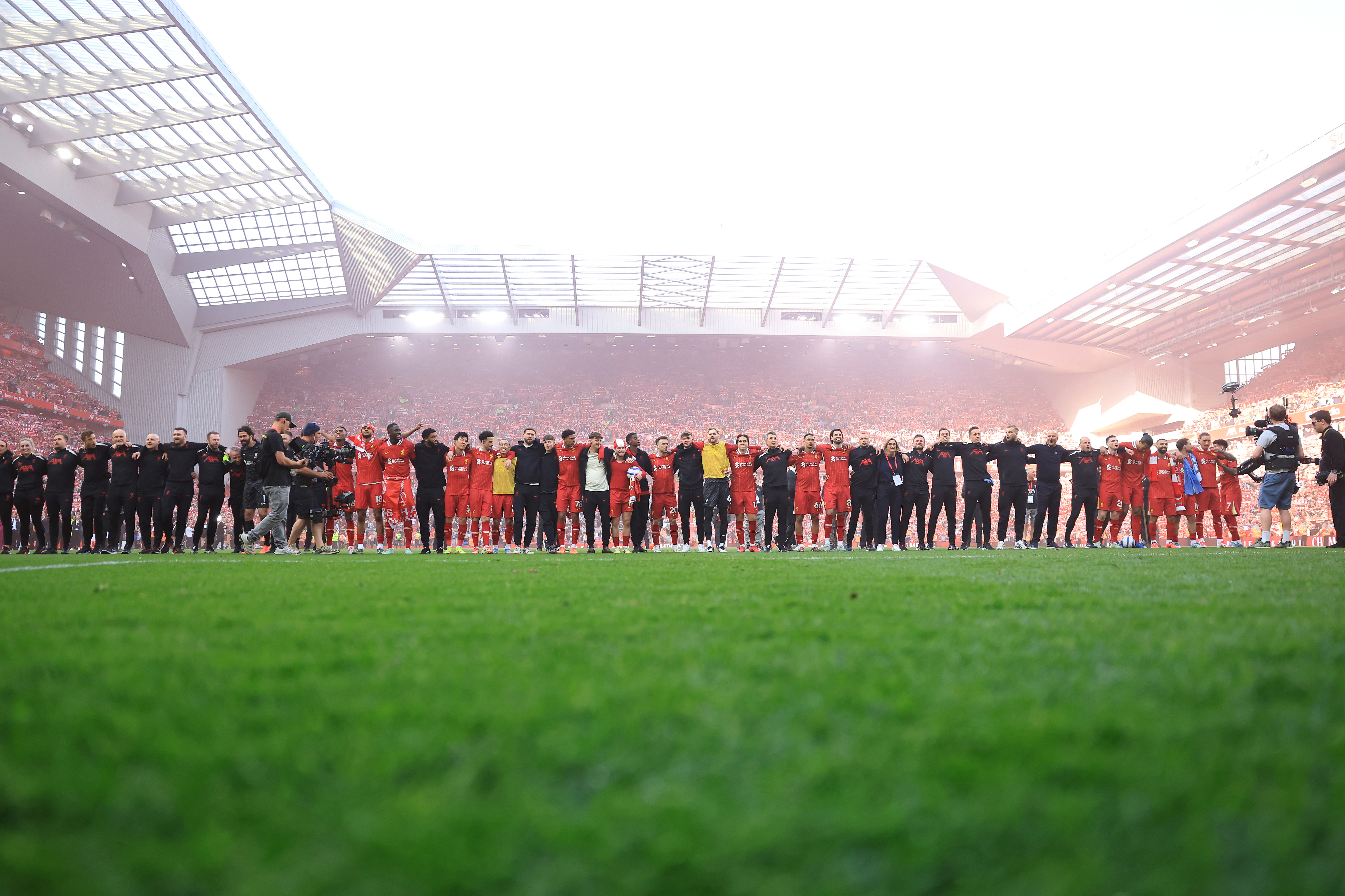 LIVERPOOL, ENGLAND - APRIL 27: Alisson Becker, Ryan Gravenberch, Cody Gakpo, Ibrahima Konate, Joe Gomez, Wataru Endo, Curtis Jones, Kostas Tsimikas, Harvey Davies, Tyler Morton, Harvey Elliott, Diogo Jota, Caoimhin Kelleher, Federico Chiesa, Trent Alexander-Arnold, Dominik Szoboszlai, Johnny Heitinga, Assistant Manager of Liverpool, Vitezslav Jaros, Arne Slot, Manger of Liverpool, Sipke Hulshoff, assistant Manager of Liverpool, Andrew Robertson, Virgil van Dijk, Mohamed Salah, Alexis Mac Allister, Darwin Nunez and Luis Diaz of Liverpool celebrate the teams victory and confirmation of winning the Premier League title after the Premier League match between Liverpool FC and Tottenham Hotspur FC at Anfield on April 27, 2025 in Liverpool, England. (Photo by Carl Recine/Getty Images)