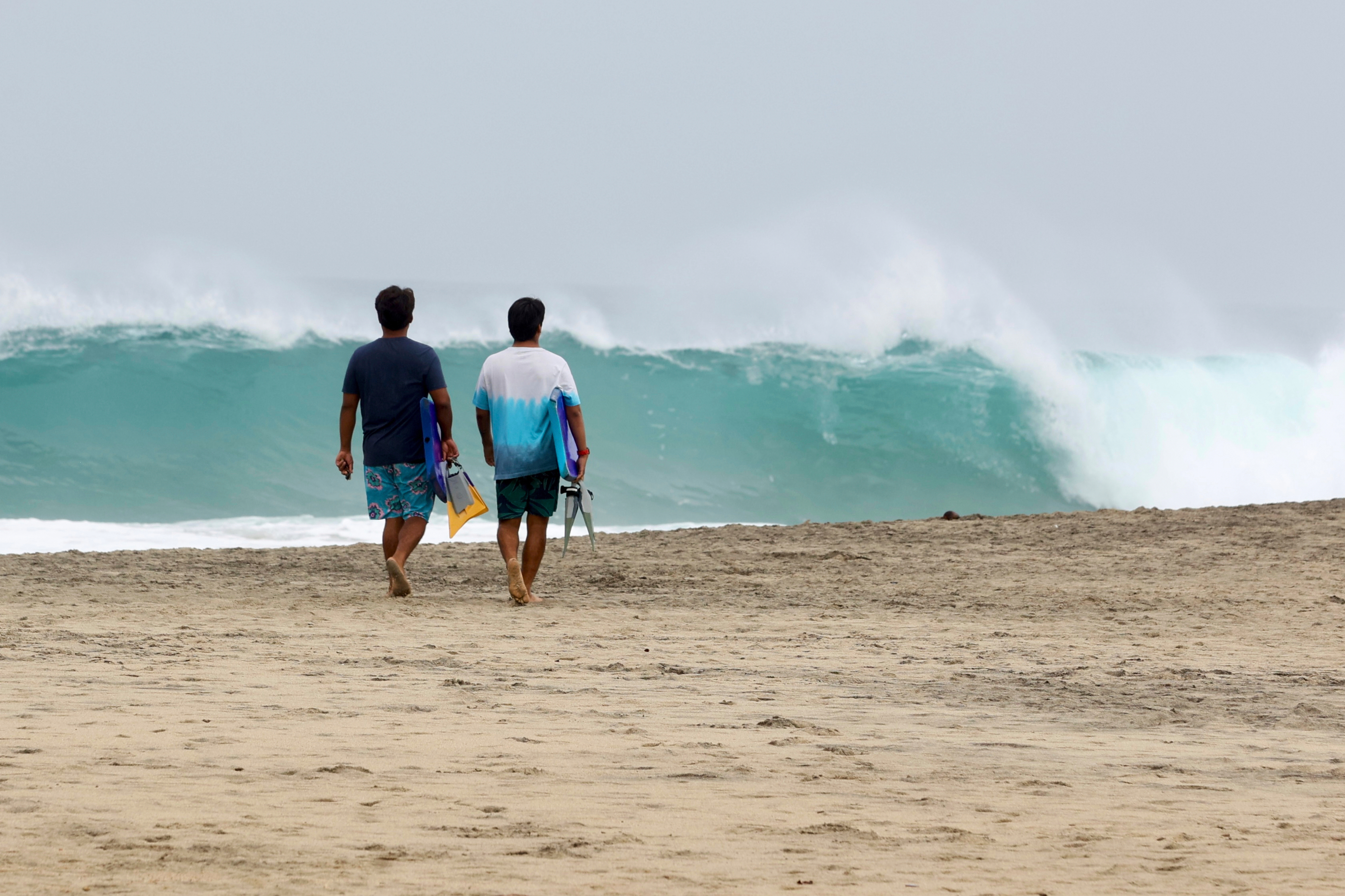 People walk on Zicatela beach prior to the arrival of Hurricane Erick in Puerto Escondido