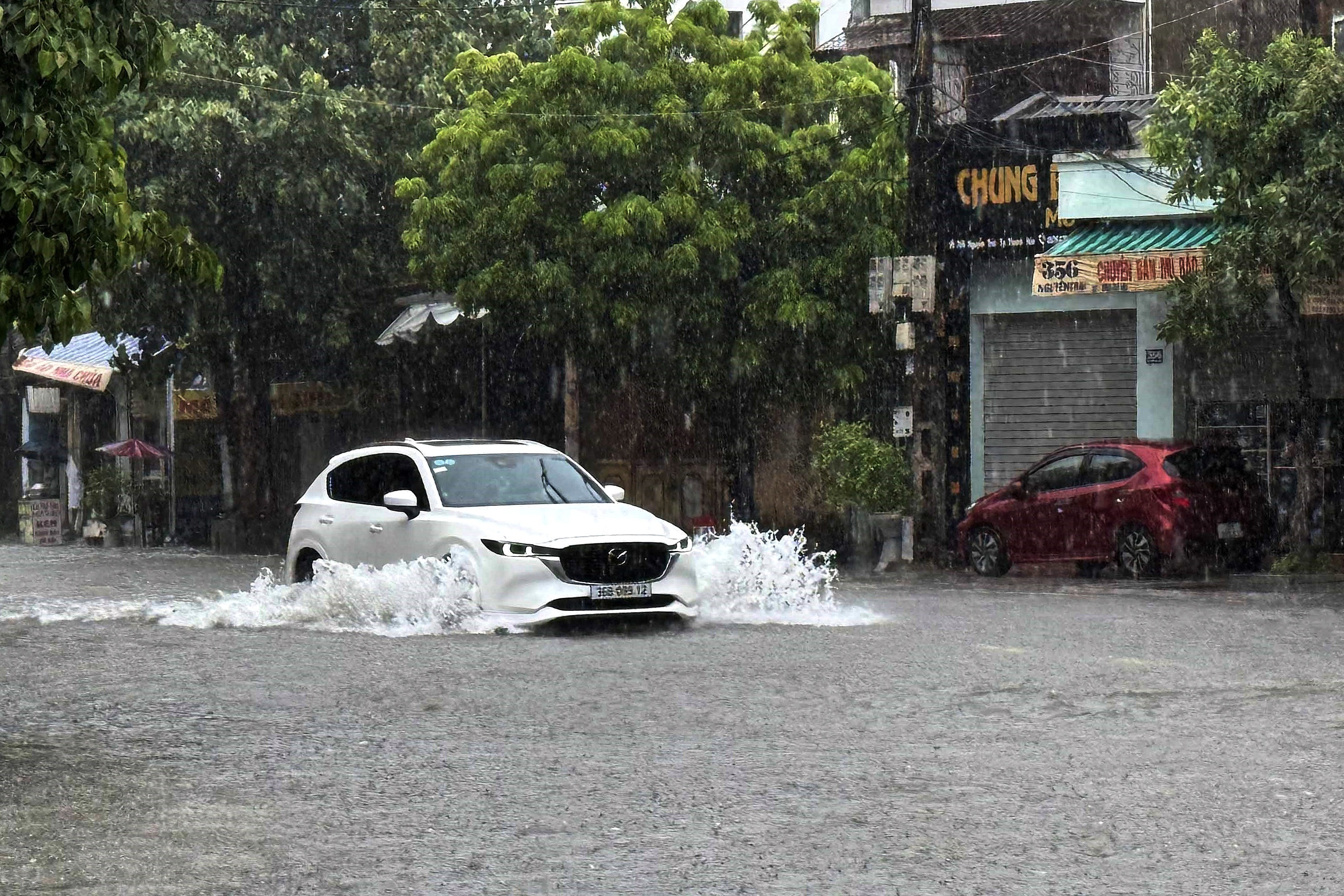 A car drives through a flooded street in Thanh Hoa, about 150km south of Hanoi, Vietnam, on July 22, 2025 [Vietnam News Agency via EPA]