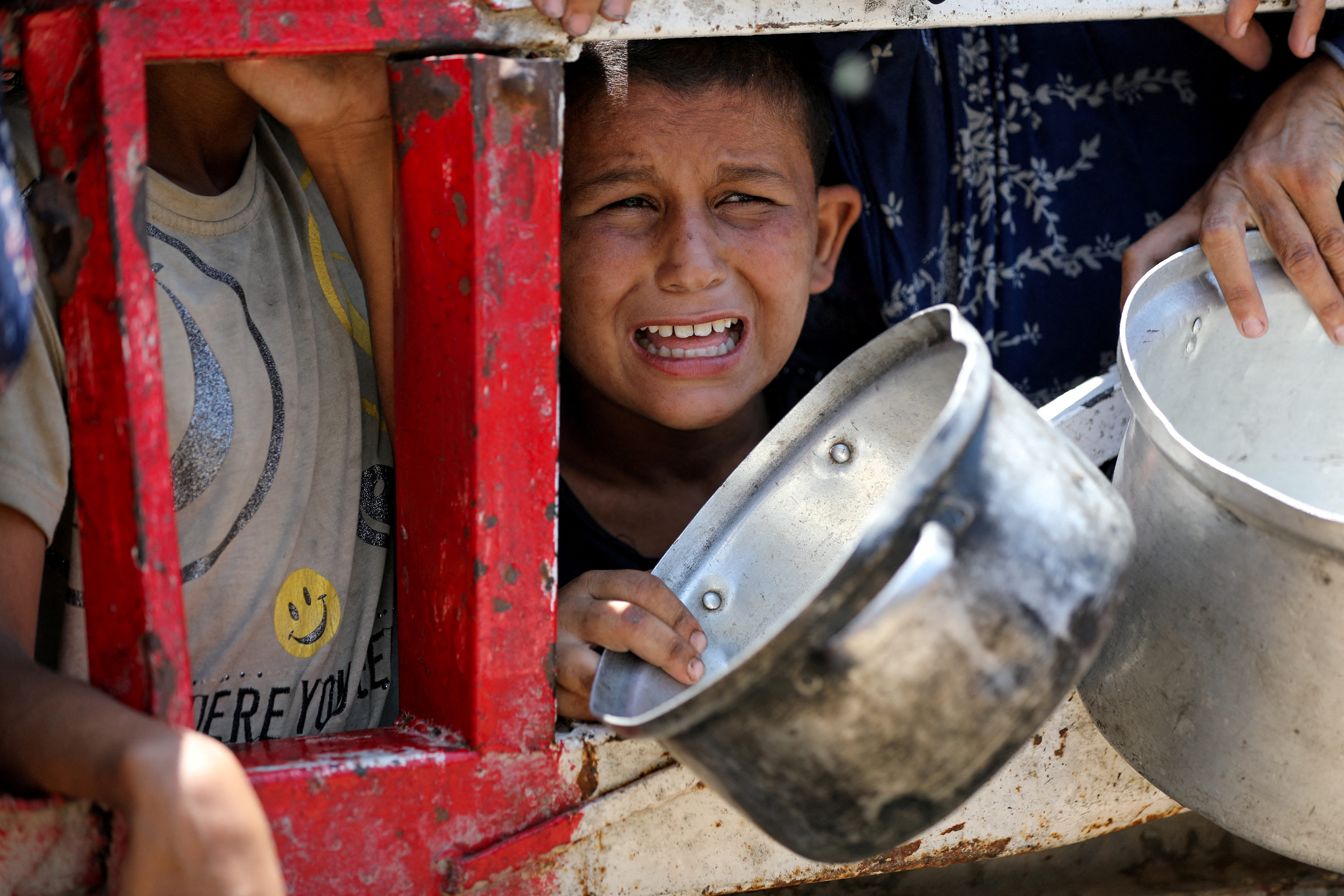 A child cries as he is crushed by crowds of starving Palestinians gathering to receive food from a charity kitchen, amid the starvation Israel has imposed on Gaza, in Gaza City, July 22, 2025