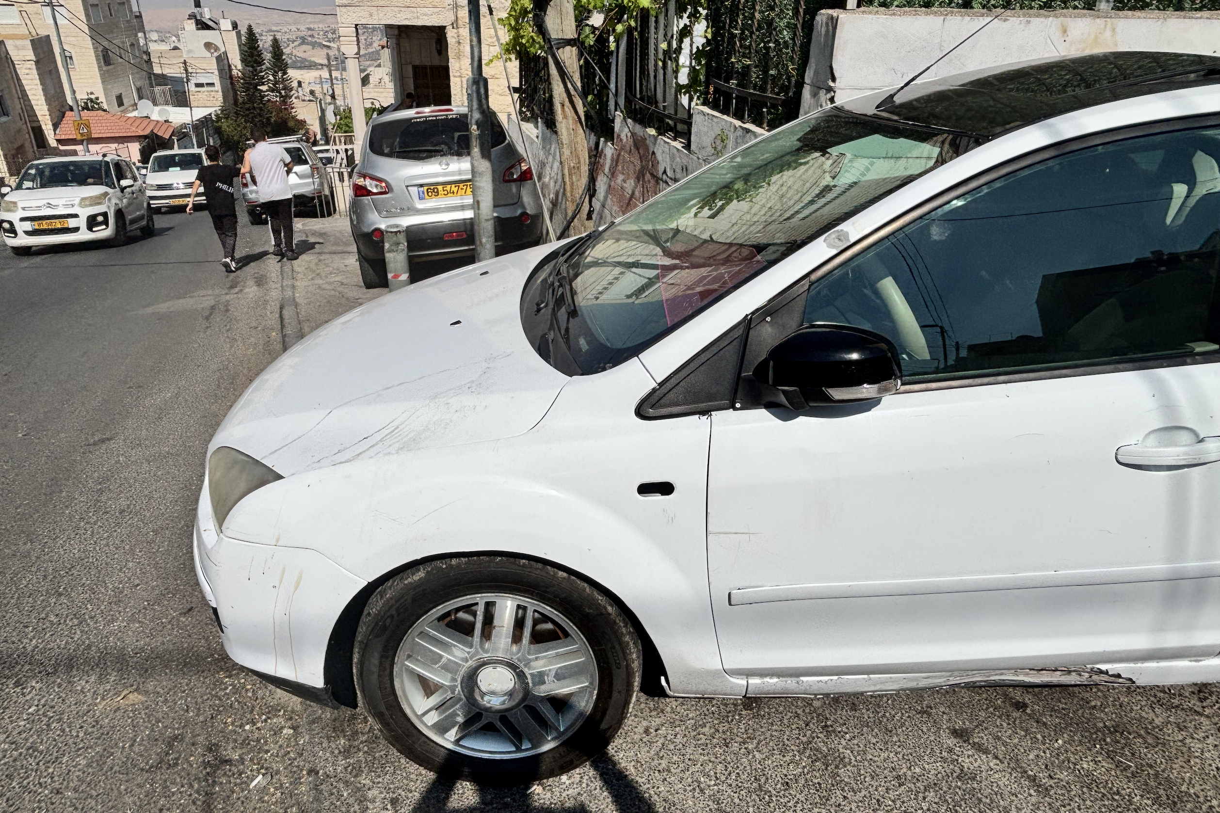 A car in the alley where the shooting took place is seen with bullet holes in the bonnet [Al Jazeera]