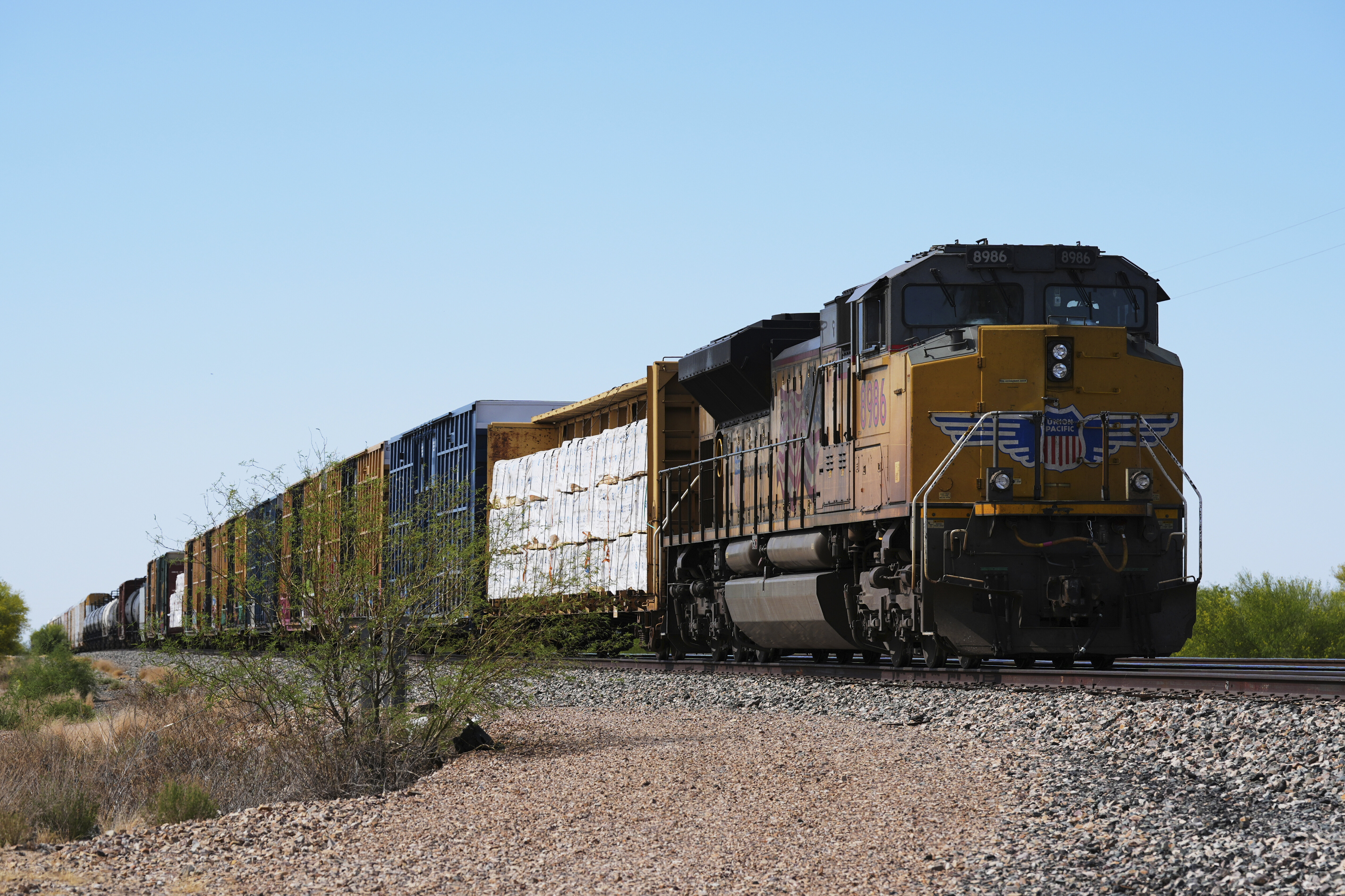 A Union Pacific freight train idles on the track as it waits to continue moving, Thursday, April 17, 2025, in Red Rock, Ariz. (AP Photo/Ross D. Franklin)