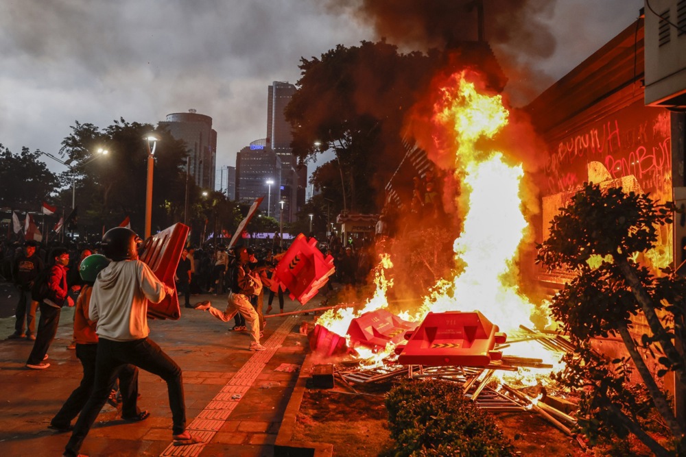 Protesters burn road barriers during a protest.