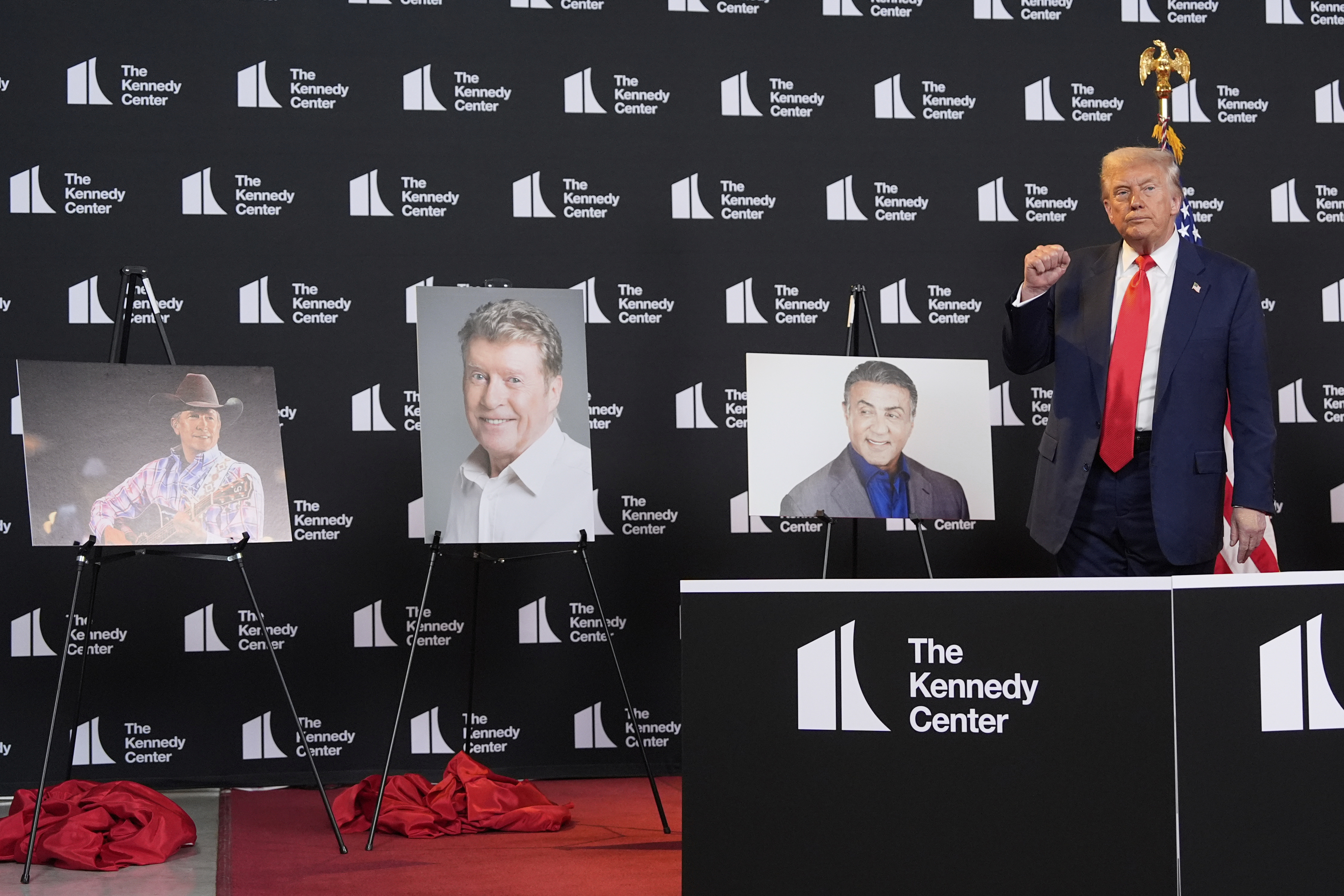 Trump stands in front of photos of his nominees for the Kennedy Center Honors