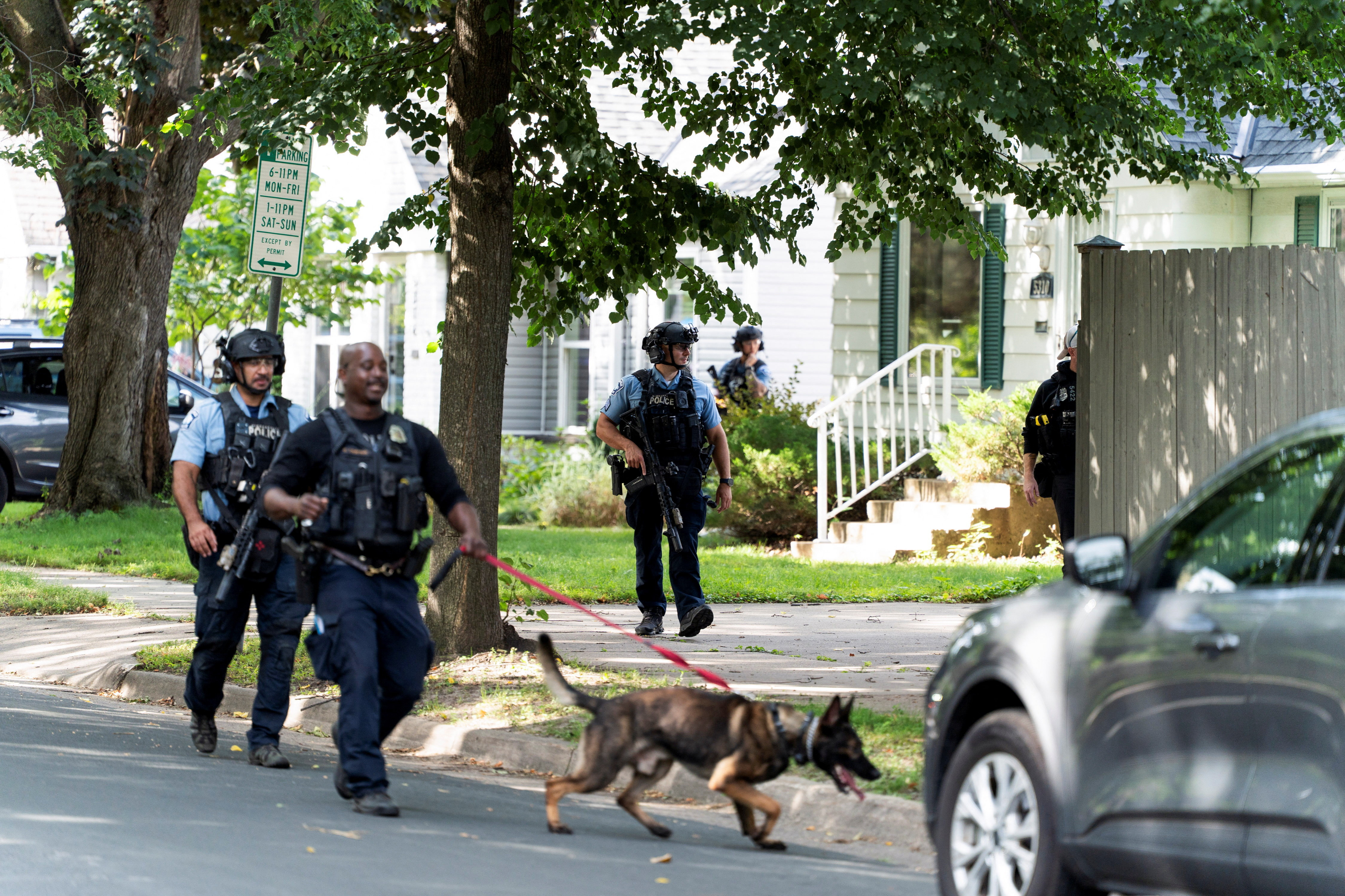 Law enforcement use a K-9 dog to search a nearby neighborhood, after a shooting at Annunciation Church, which is also home to an elementary school, in Minneapolis, Minnesota, U.S. August 27, 2025. REUTERS/Tim Evans