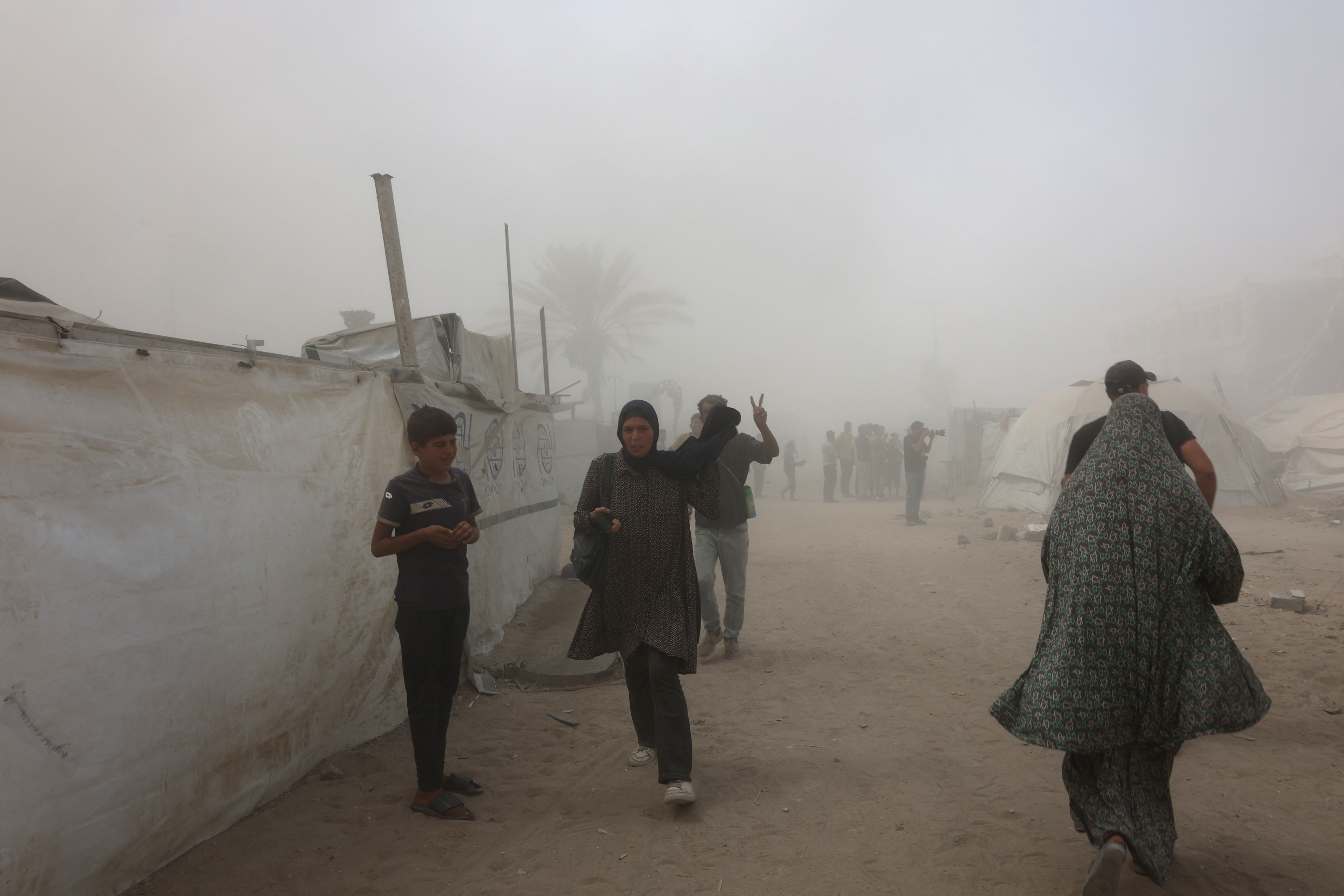 Palestinians evacuate as smoke covers the area after Israel issued evacuation orders ahead of a military strike on the Mushtaha Tower in Gaza City, on September 5, 2025, amid the war between Israel and the Hamas militant movement. The Israeli military said it struck a high-rise in Gaza City on September 5, shortly after announcing it would target tall buildings identified as being used by Hamas ahead of its forces' planned conquest of the urban hub. (Photo by Omar AL-QATTAA / AFP)