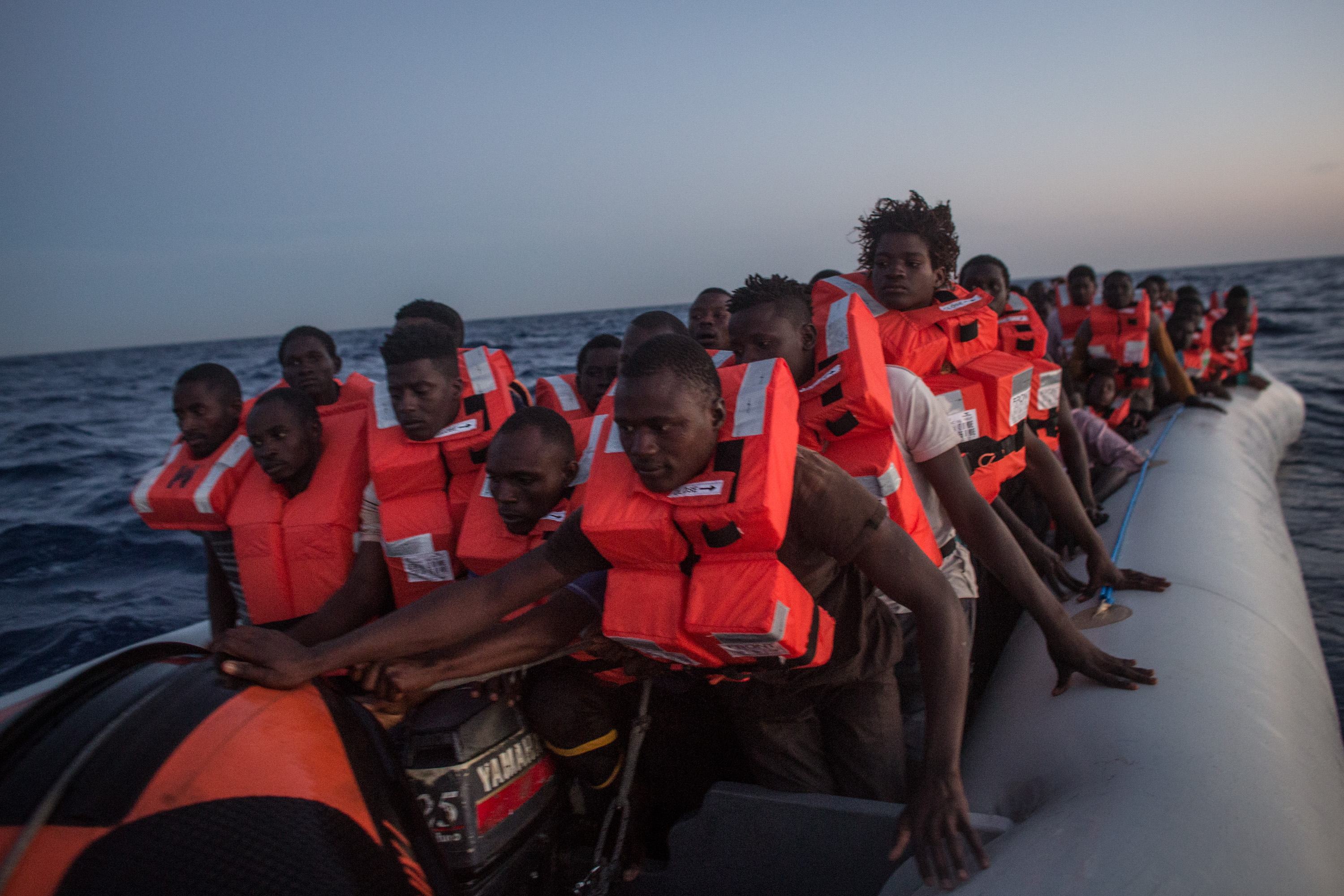 LAMPEDUSA, ITALY - JUNE 10: Refugees and migrants wait in a small rubber boat to be rescued by crewmembers from the Migrant Offshore Aid Station (MOAS) Phoenix vessel on June 10, 2017 off Lampedusa, Italy. An estimated 230,000 refugees and migrants will arrive in Italy this year as numbers of refugees and migrants attempting the dangerous central mediterranean crossing from Libya to Italy continues to rise since the same time last year. So far this year more than 58,000 people have arrived in Italy and 1,569 people have died attempting the crossing. Libya continues to be the primary departure point for refugees and migrants taking the central mediterranean route to Sicily. In an attempt to slow the flow of migrants, Italy recently signed a deal with Libya, Chad and Niger outlining a plan to increase border controls and add new reception centers in the African nations, which are key transit points for migrants heading to Italy. MOAS is a Malta based NGO dedicated to providing professional search-and-rescue assistance to refugees and migrants in distress at sea. Since the start of the year MOAS have rescued and assisted more than 4000 people and are currently patrolling and running rescue operations in international waters off the coast of Libya. (Photo by Chris McGrath/Getty Images)
