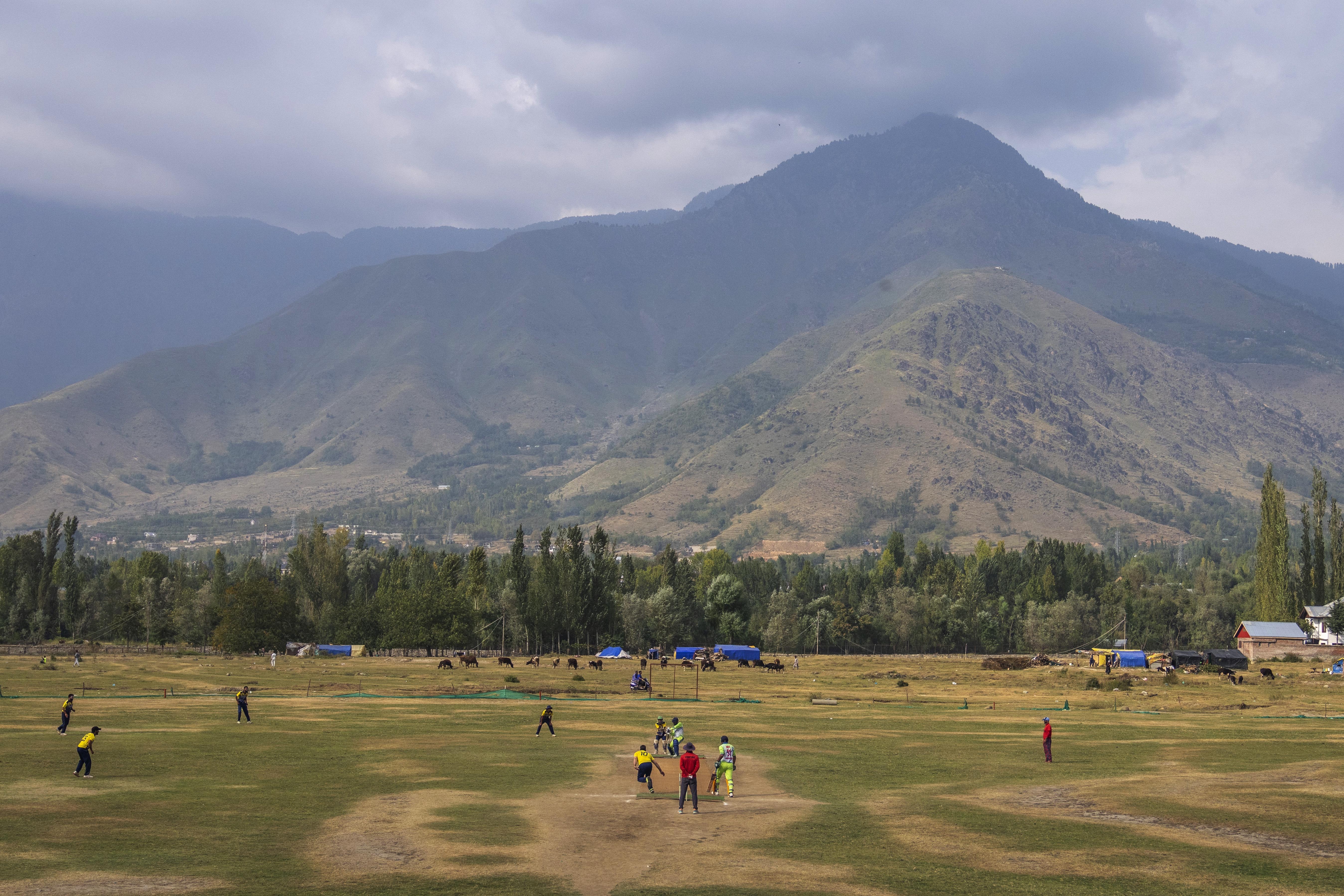 Kashmiri men play cricket on the outskirts of Srinagar in Indian-administered Kashmir