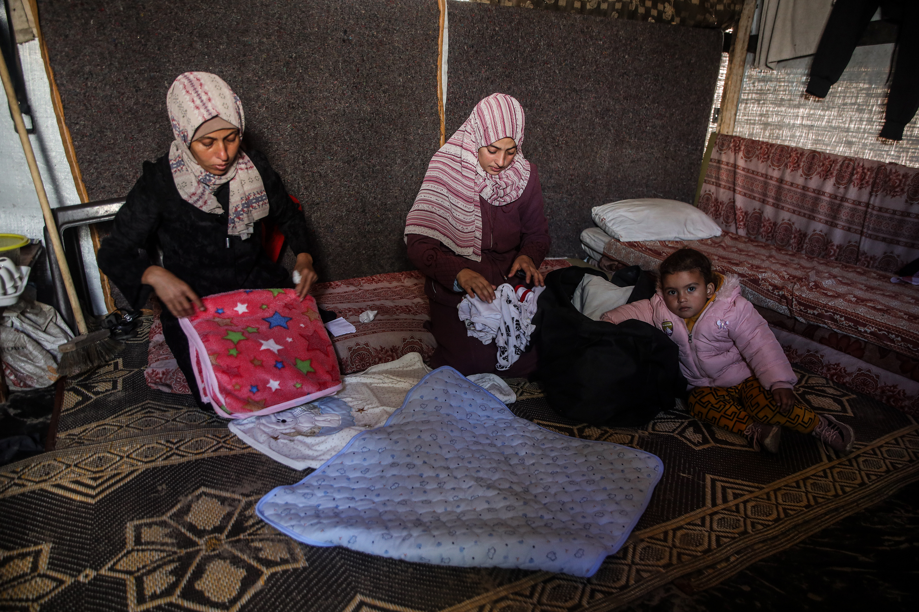 The family lives in a tent made of fabric and nylon in Khan Younis’ camps after their displacement a year ago and the destruction of their home [Abdelhakim Abu Riash, Al Jazeera]