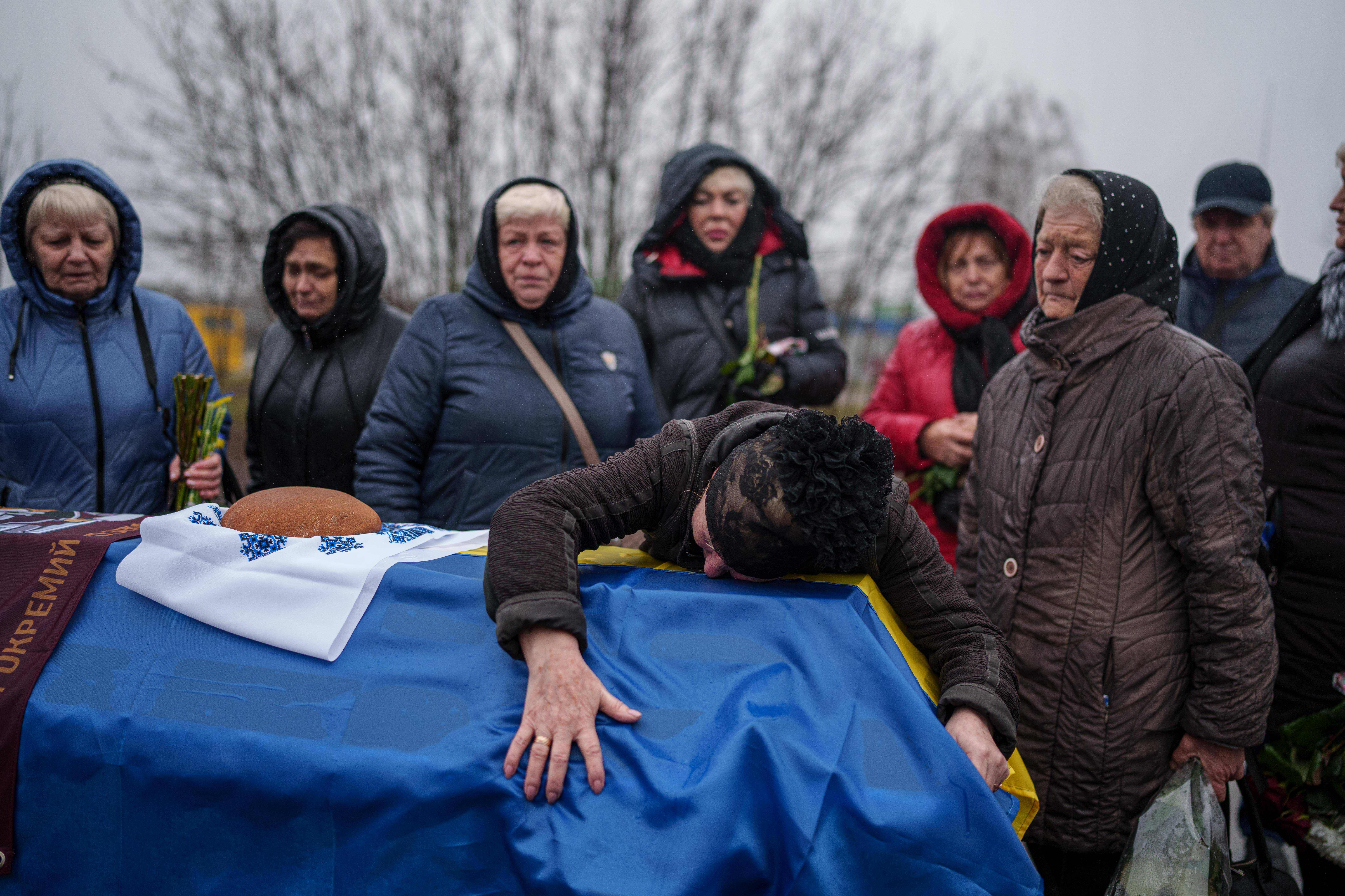 A woman grieves over the coffin of her son, a Ukrainian serviceman who was killed in fighting with Russian forces near Pokrovsk, during his funeral ceremony in Boiarka, Ukraine, on Wednesday, December 3, 2025