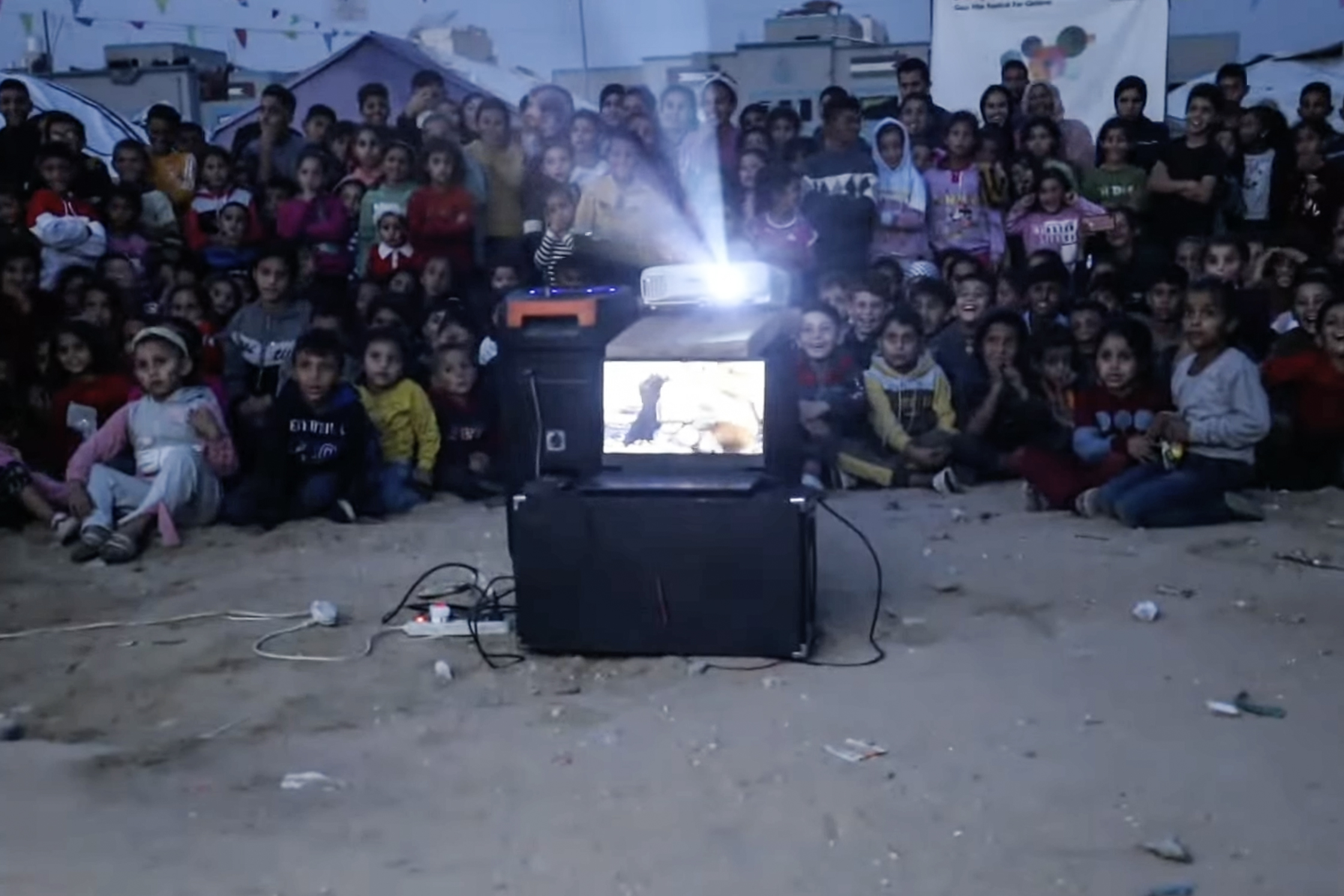 Children watch a film during an outdoor screening in Gaza City