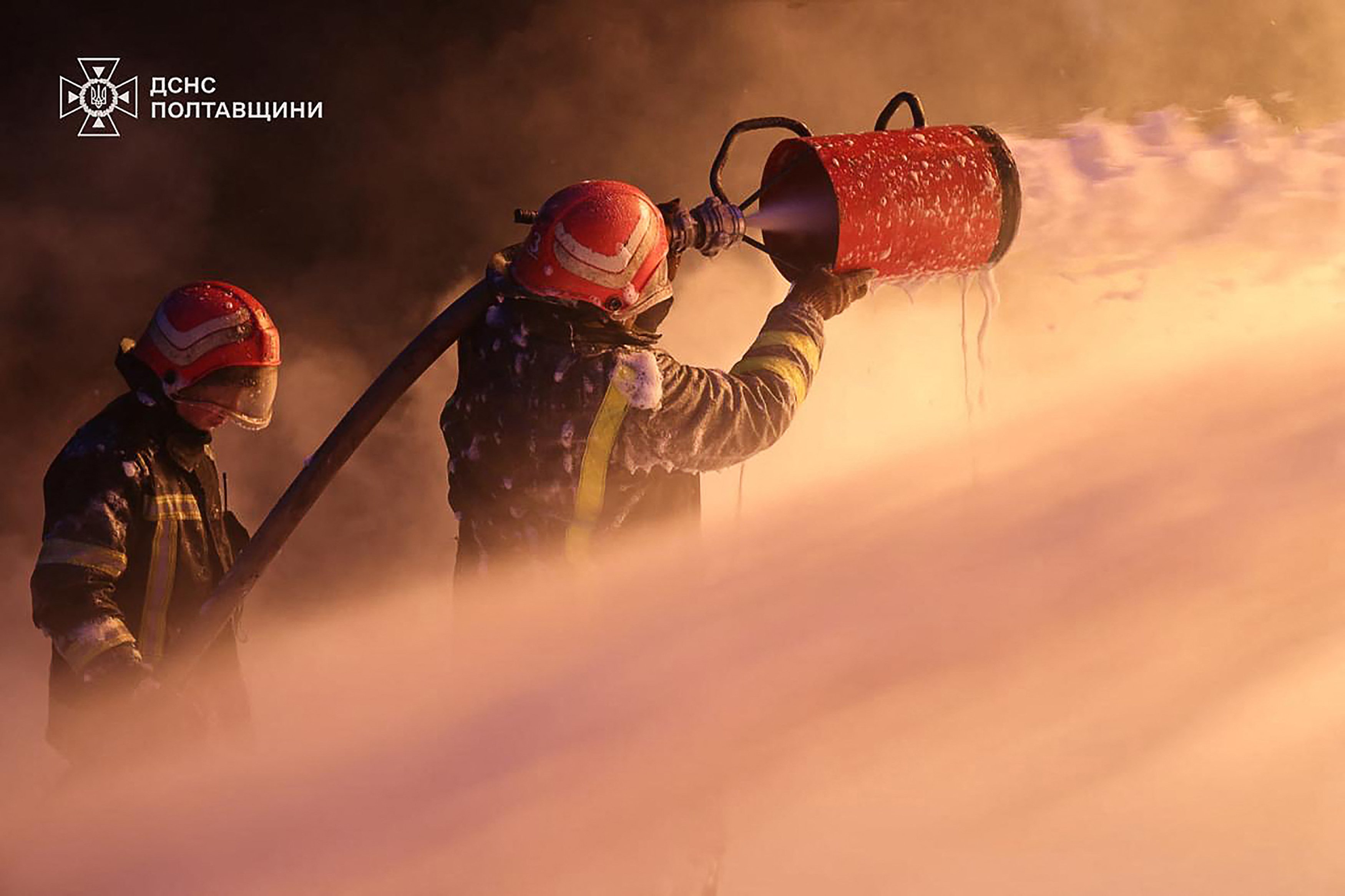 This handout picture taken and released by Ukrainian State Emergency Service on December 7, 2025 shows firefighters working to extinguish a fire following a Russian drone and missile attacks to industrial and energy infrastructures in the Poltava region, amid the Russian invasion in Ukraine.